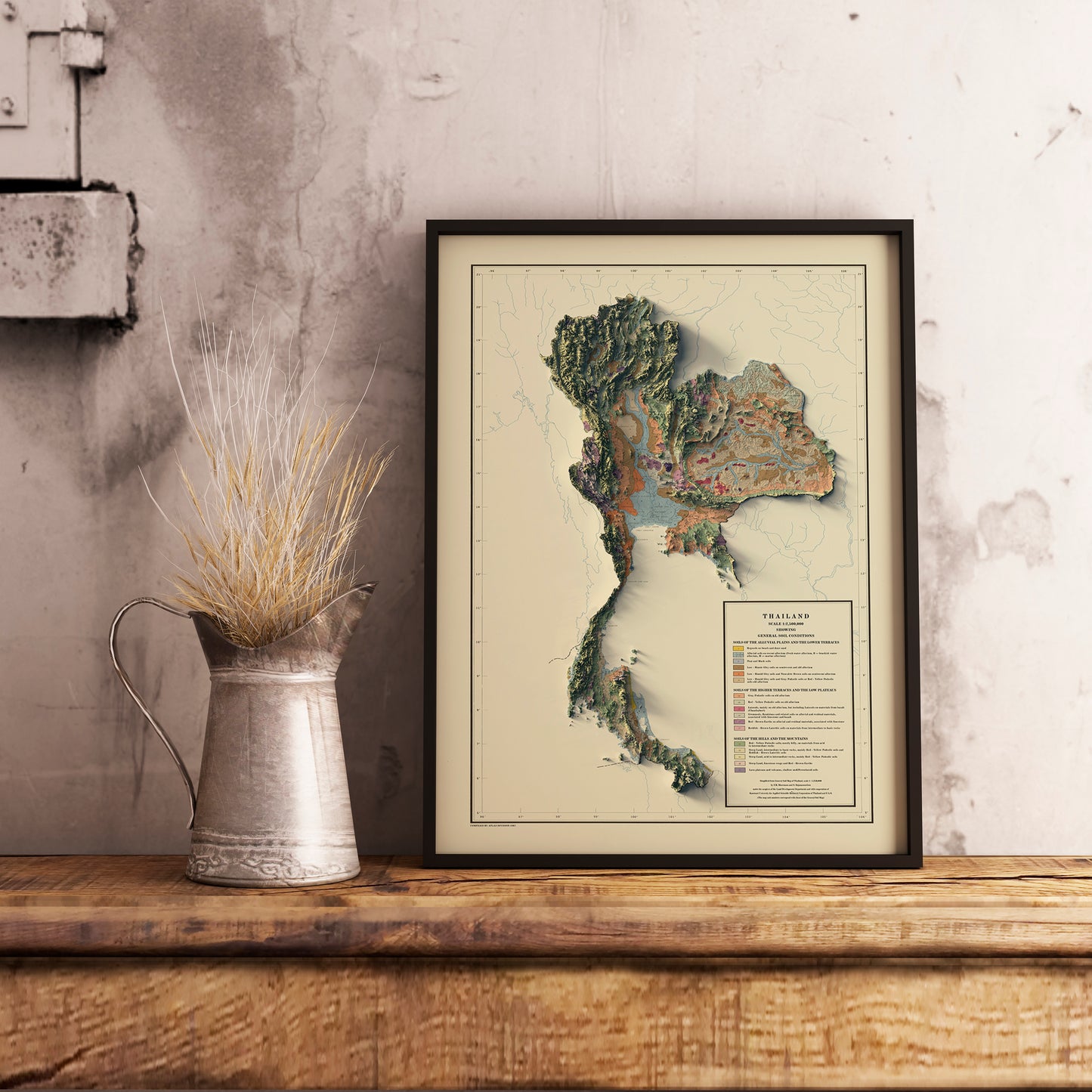 Vintage Thailand shaded relief map in black frame. Realistic terrain art print for home decor, displayed on rustic wooden table