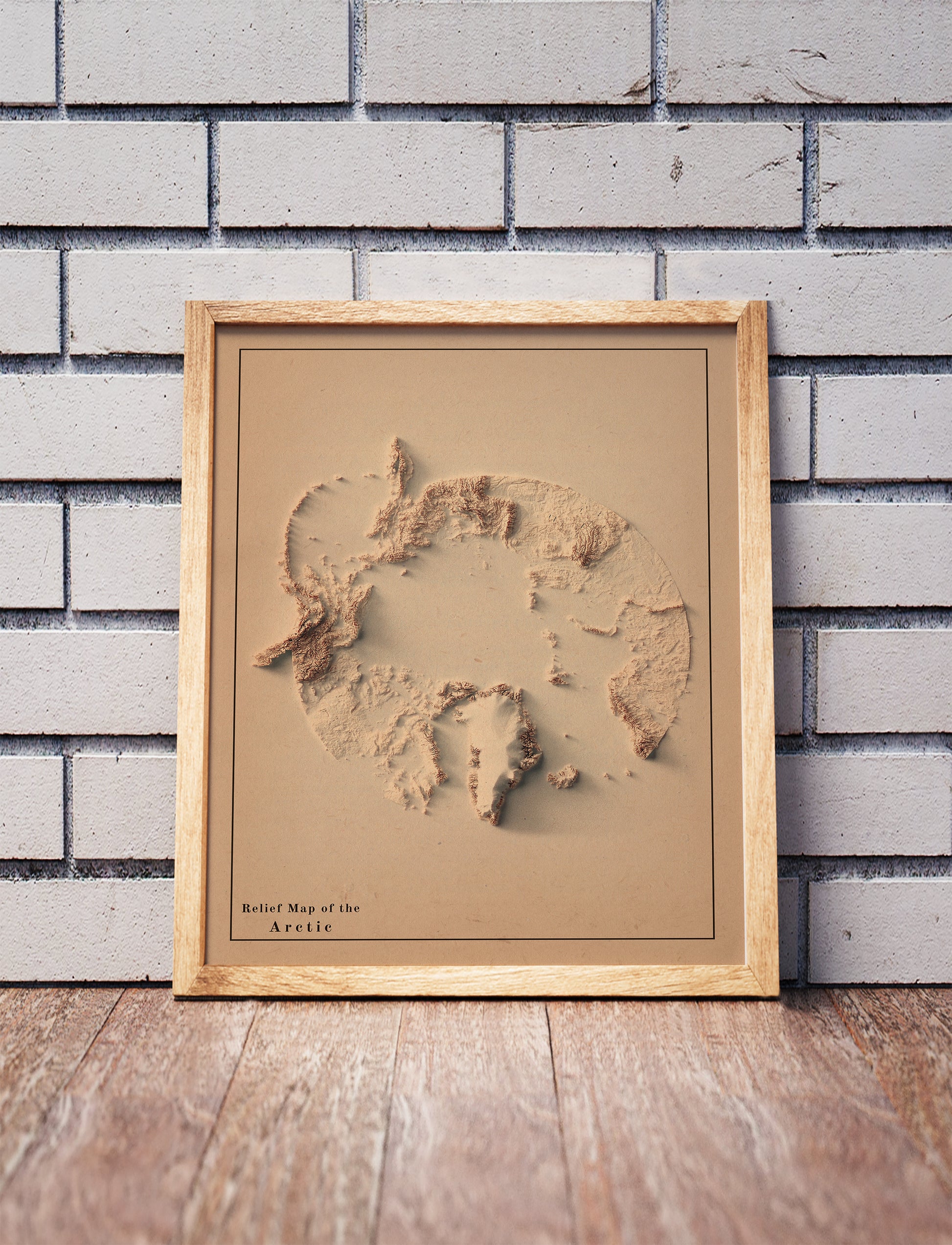 Vintage Arctic shaded relief map in a wooden frame. Realistic terrain art print for home decor, displayed against a brick wall