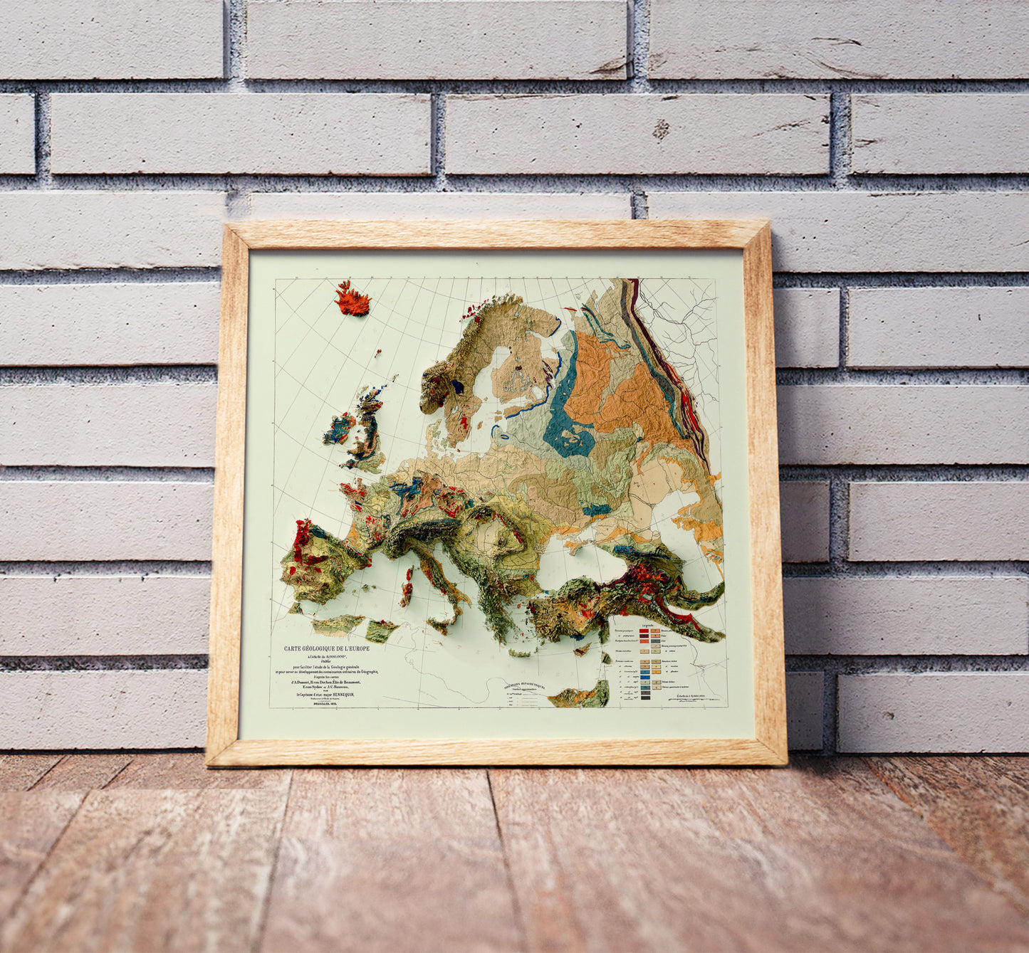 Vintage Europe shaded relief map in a wooden frame. Realistic terrain art print for home decor, displayed against a brick wall