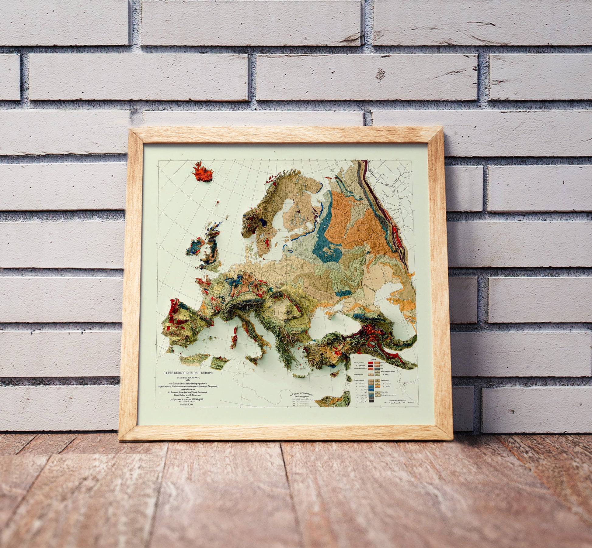 Vintage Europe shaded relief map in a wooden frame. Realistic terrain art print for home decor, displayed against a brick wall