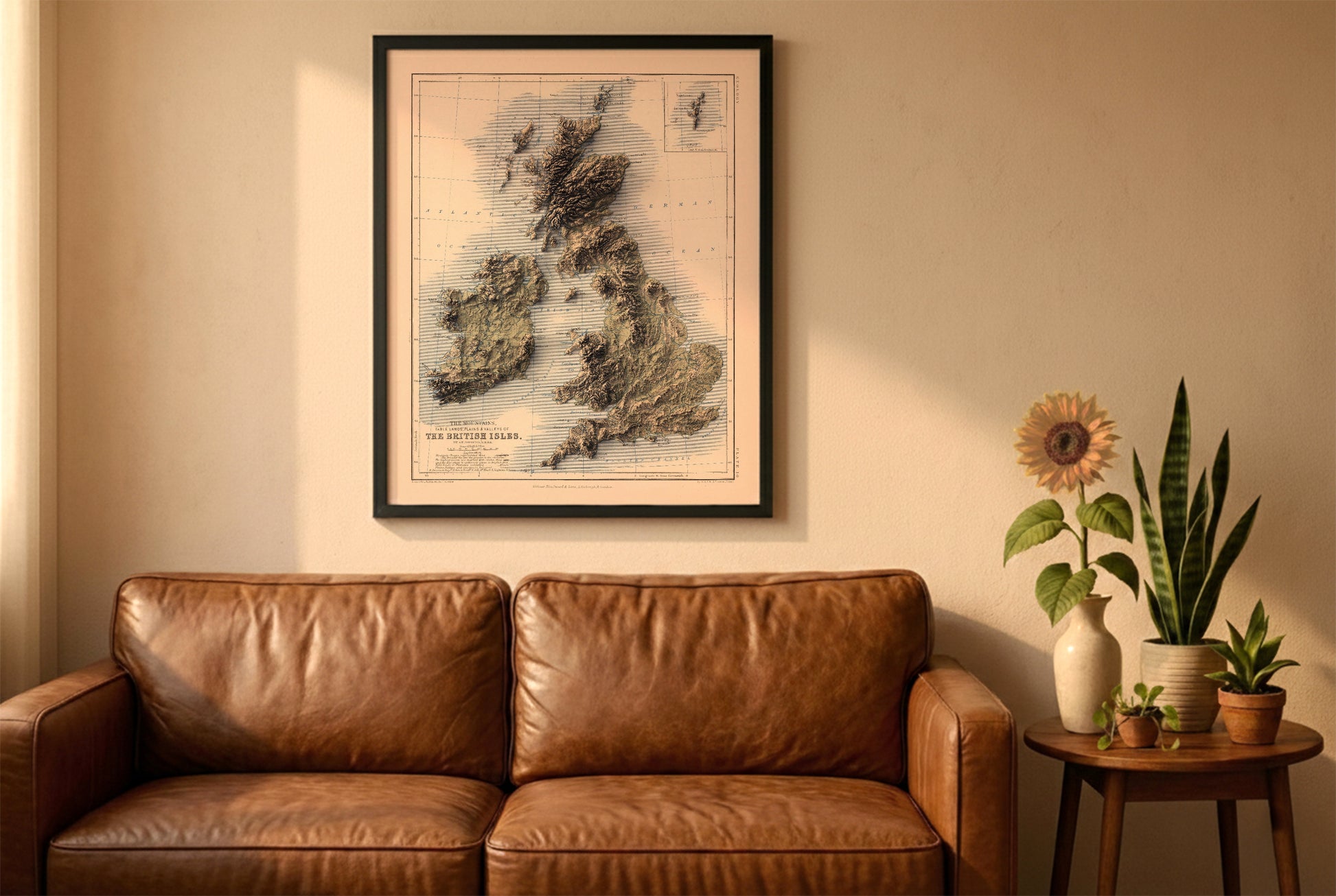 united kingdom and ireland vintage relief map in a black frame above a brown leather sofa. Boho living room with warm sunlight, sunflower, and indoor plants on a wooden side table