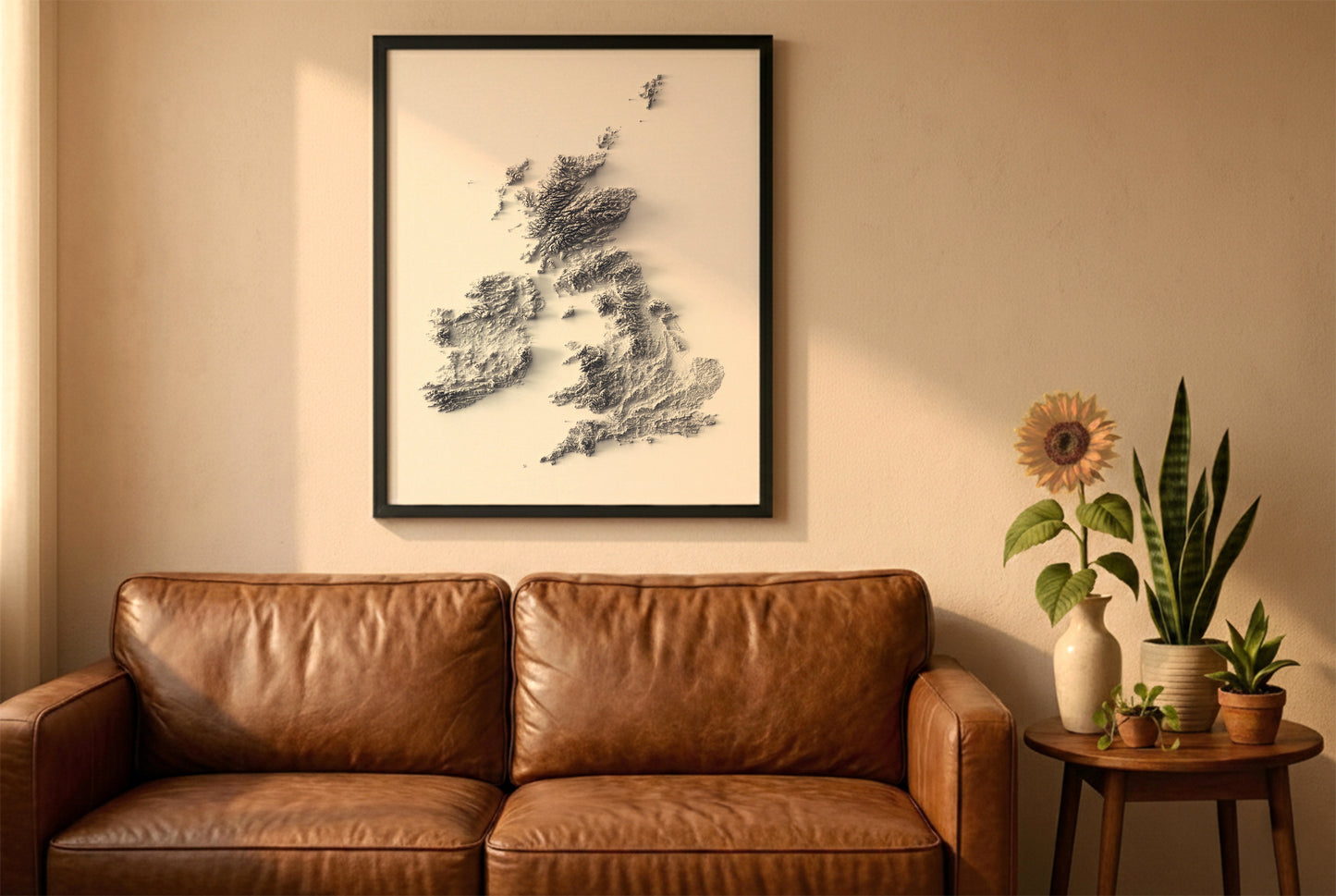 united kingdom and ireland relief map in a black frame above a brown leather sofa. Boho living room with warm sunlight, sunflower, and indoor plants on a wooden side table