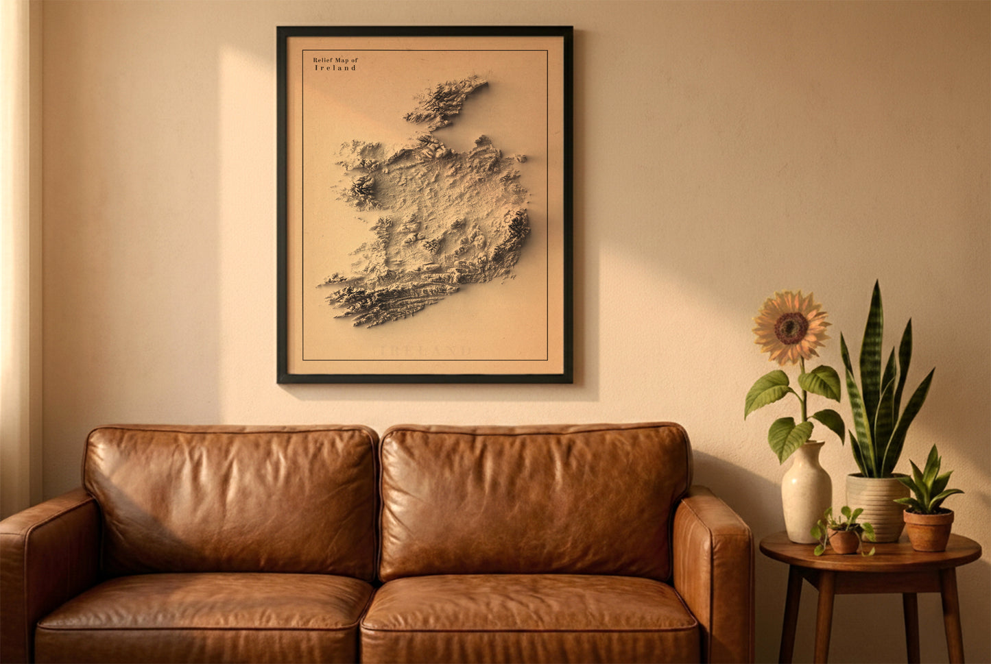 Ireland relief map in a black frame above a brown leather sofa. Boho living room with warm sunlight, sunflower, and indoor plants on a wooden side table