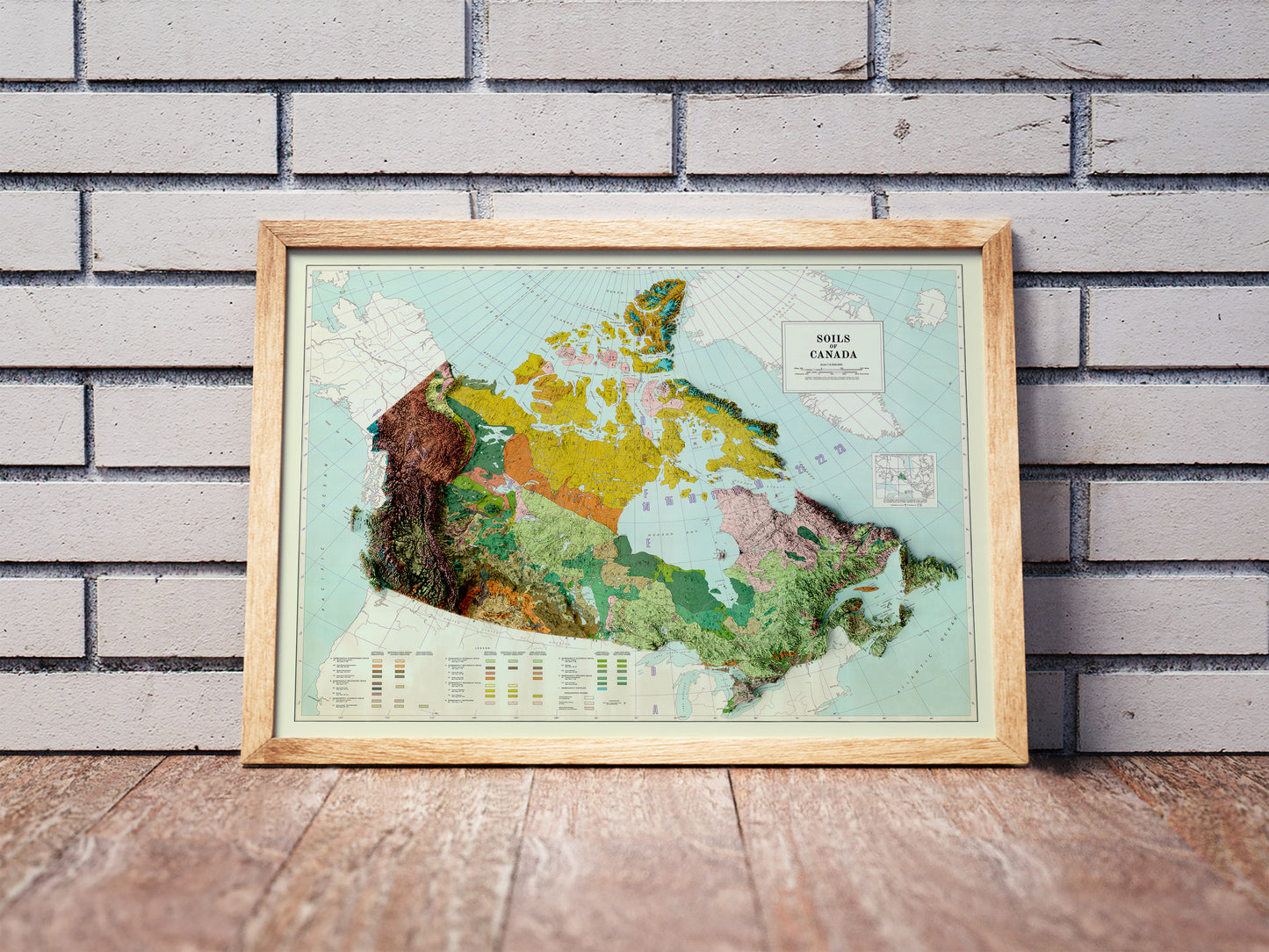 Vintage Cambodia shaded relief map in a wooden frame. Realistic terrain art print for home decor, displayed against a brick wall