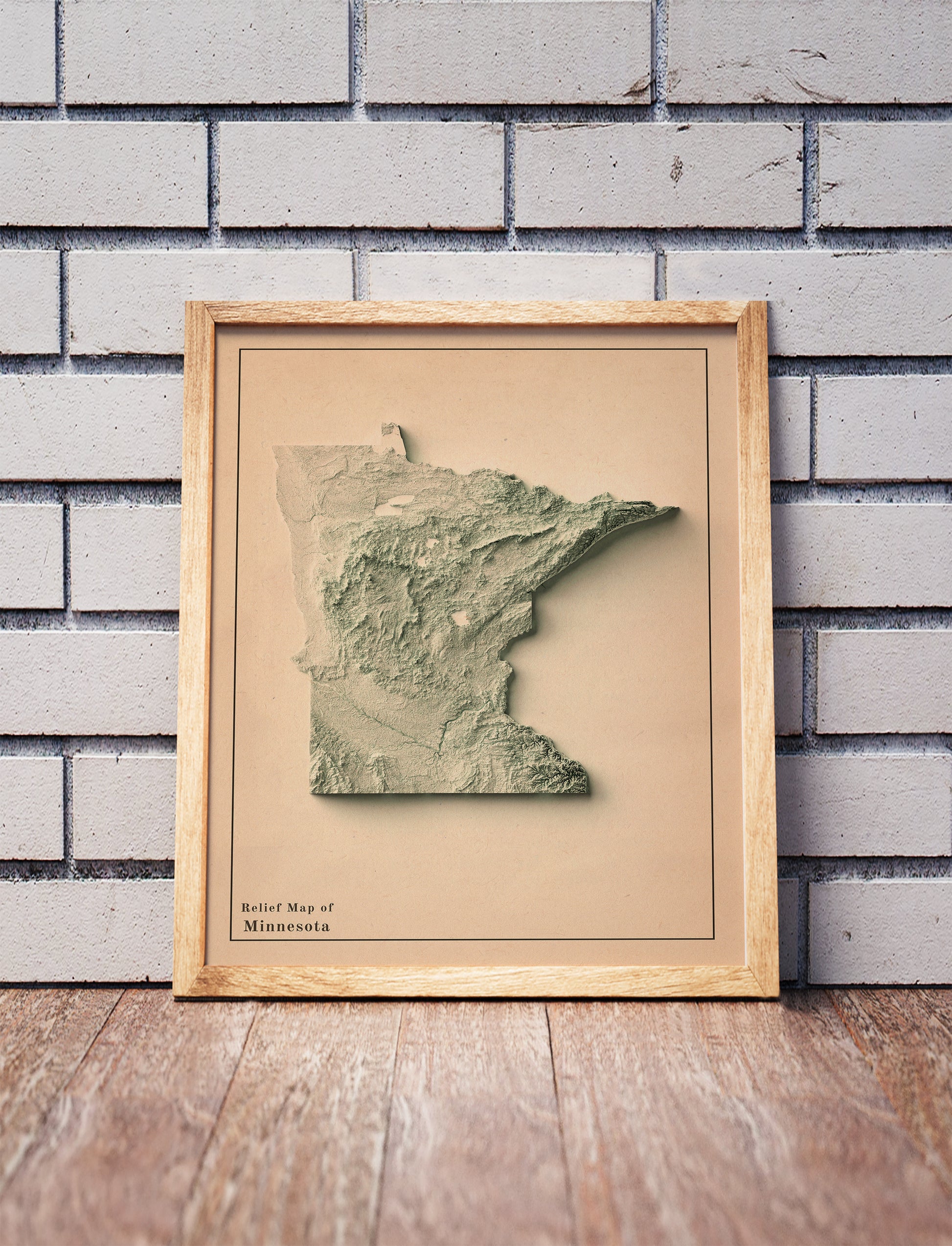 Vintage Minnesota shaded relief map in a wooden frame. Realistic terrain art print for home decor, displayed against a brick wall