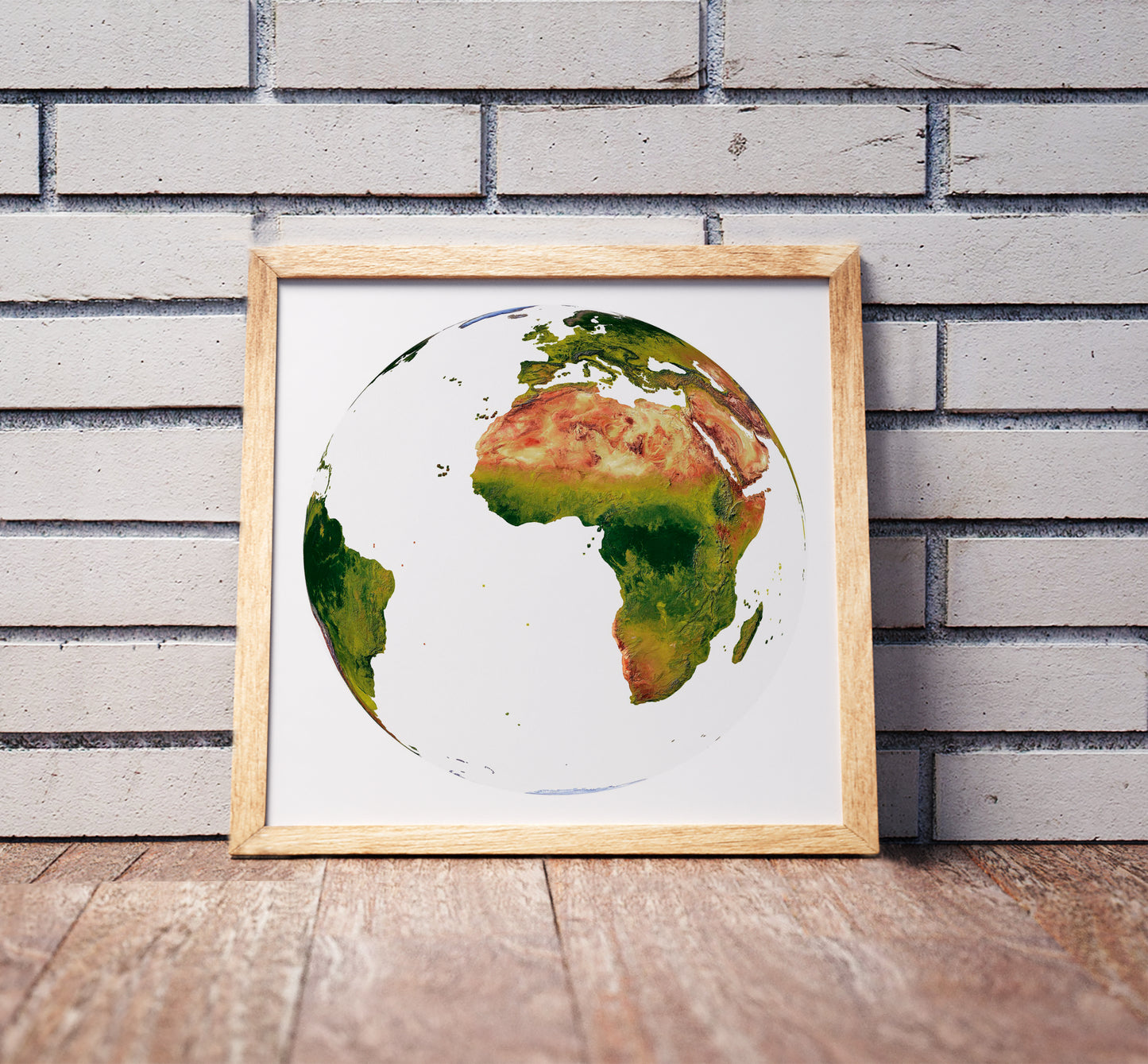 Vertical Perspective projection shaded relief world map in a wooden frame. Realistic terrain art print for home decor, displayed against a brick wall