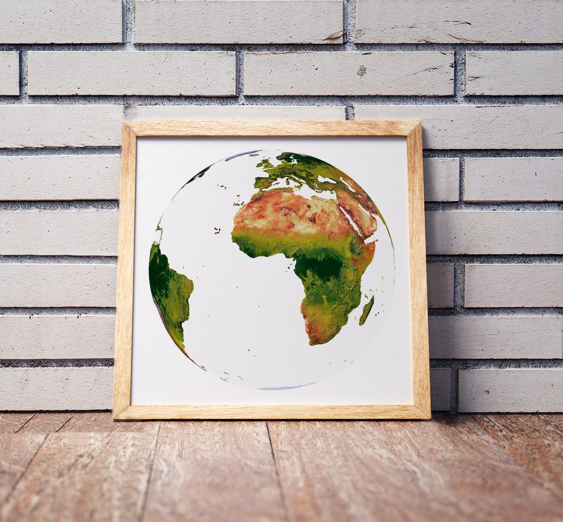 Vertical Perspective projection shaded relief world map in a wooden frame. Realistic terrain art print for home decor, displayed against a brick wall