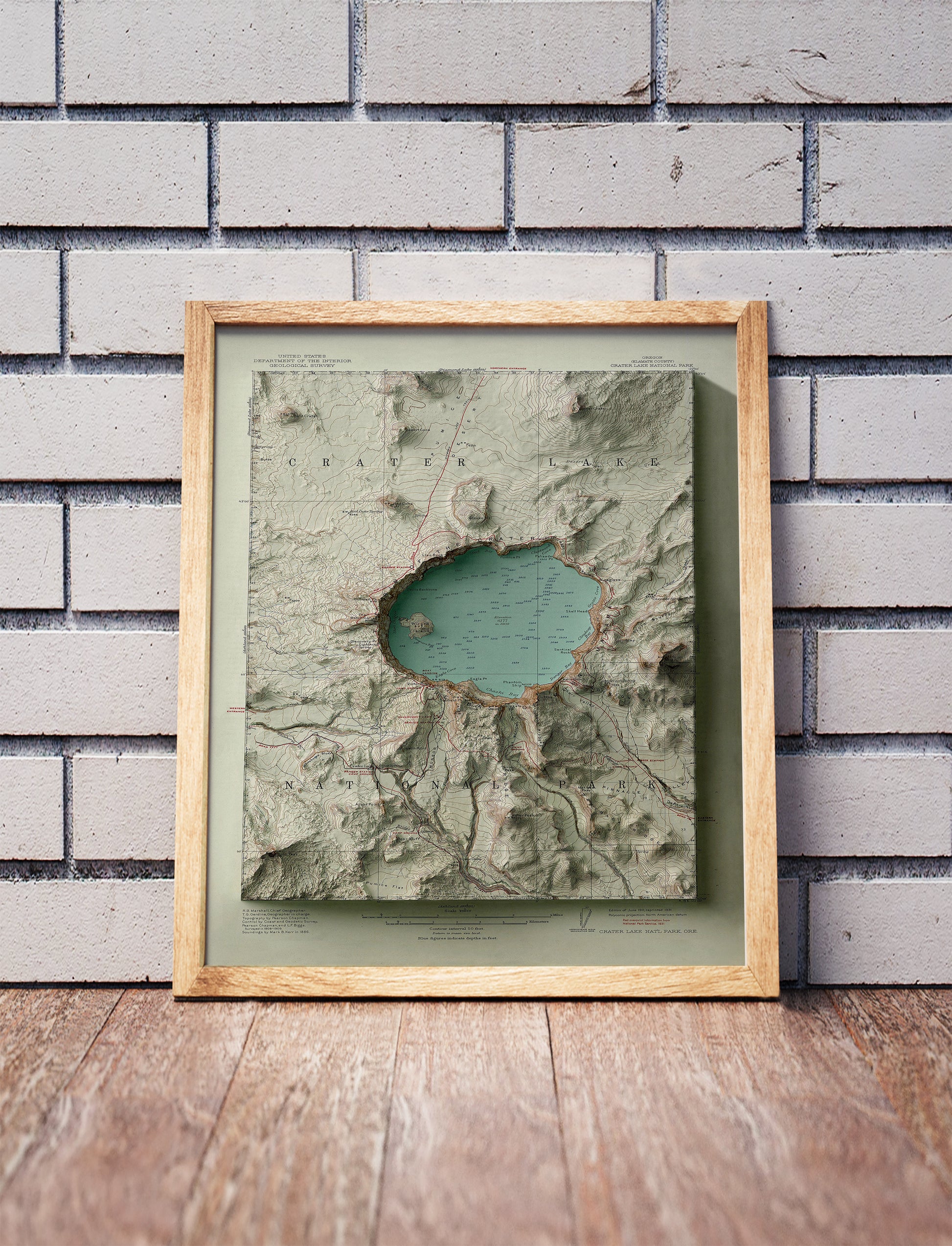 Vintage Crater Lake, Oregon, shaded relief map in a wooden frame. Realistic terrain art print for home decor, displayed against a brick wall