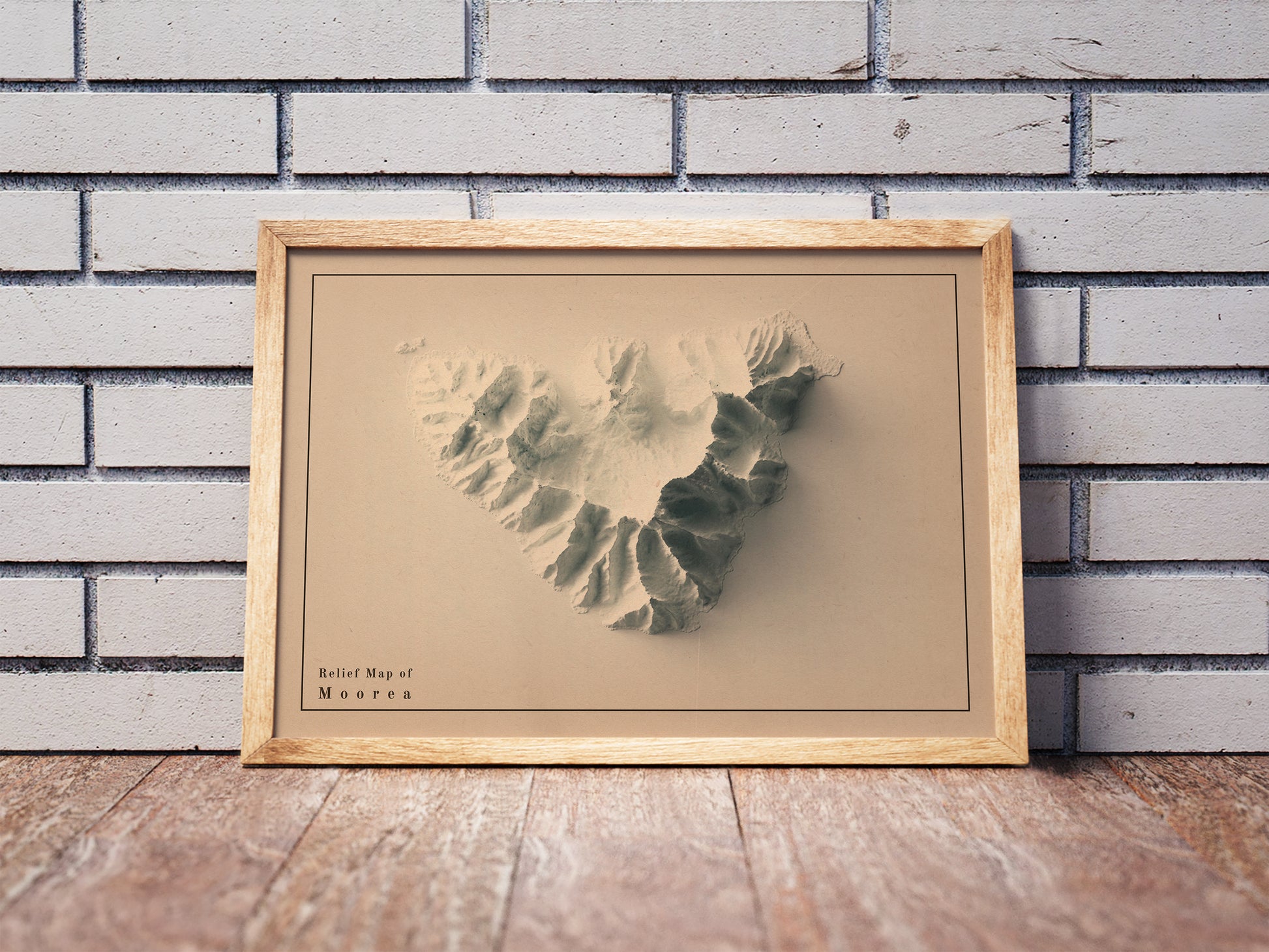 Vintage Moorea shaded relief map in a wooden frame. Realistic terrain art print for home decor, displayed against a brick wall