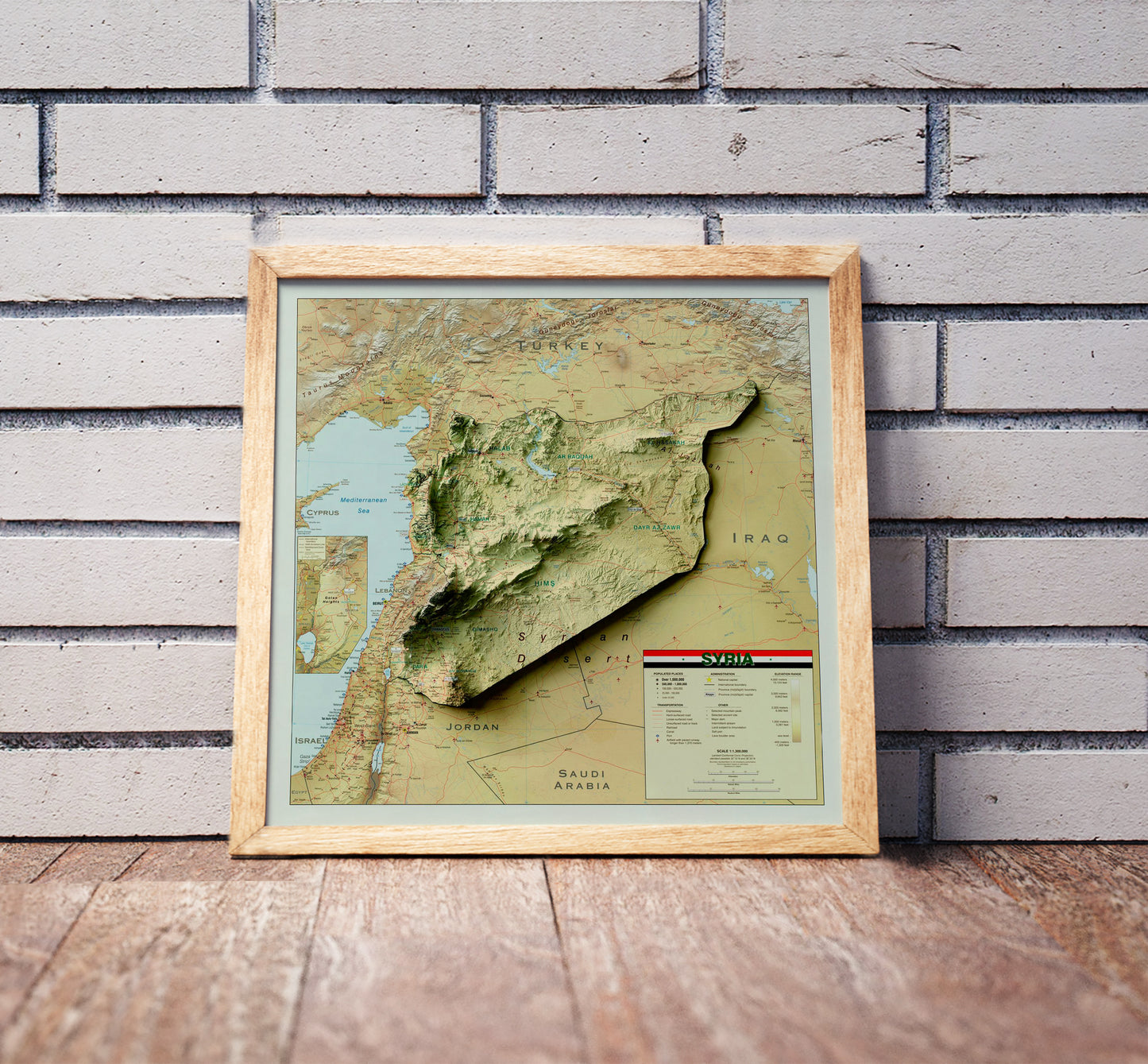 Vintage Syria shaded relief map in a wooden frame. Realistic terrain art print for home decor, displayed against a brick wall
