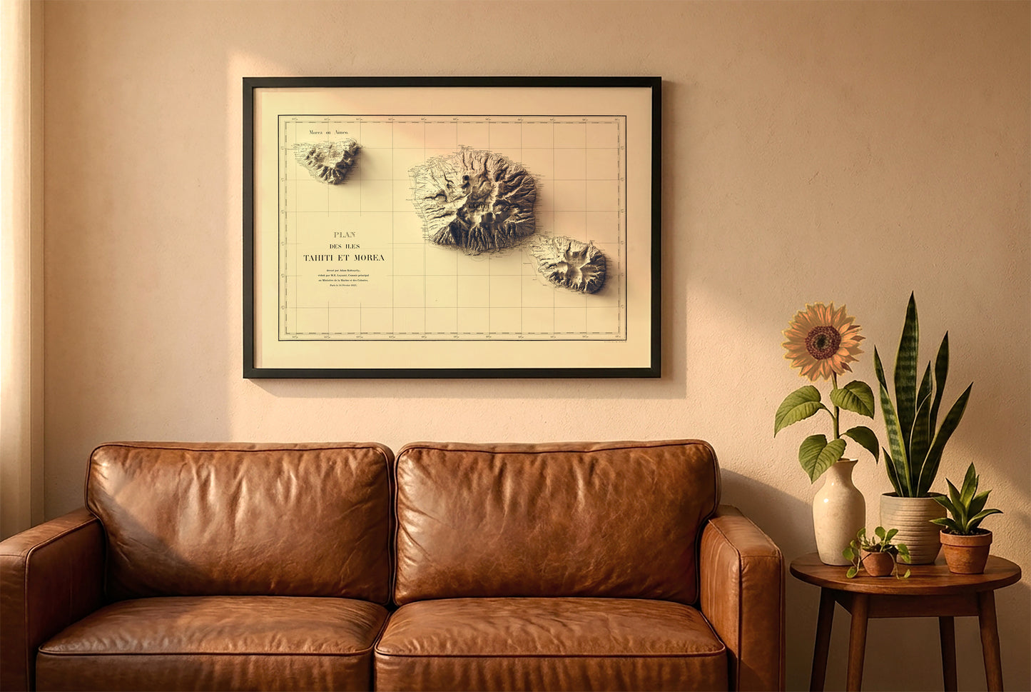Tahiti vintage relief map in a black frame above a brown leather sofa. Boho living room with warm sunlight, sunflower, and indoor plants on a wooden side table