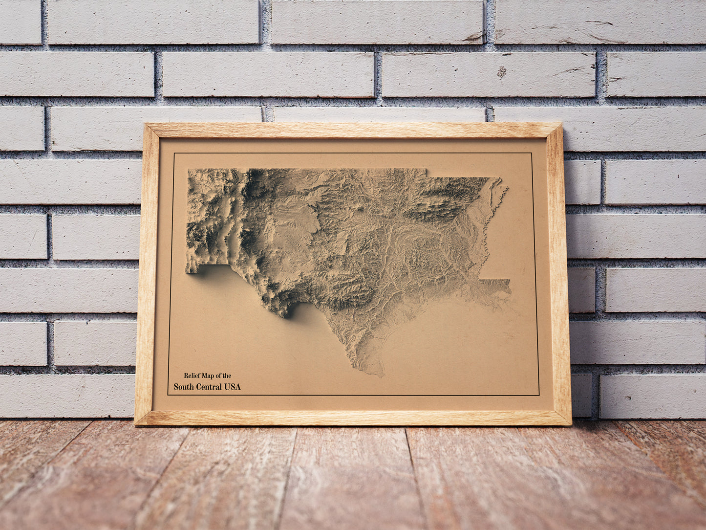 Vintage South Central USA shaded relief map in a wooden frame. Realistic terrain art print for home decor, displayed against a brick wall