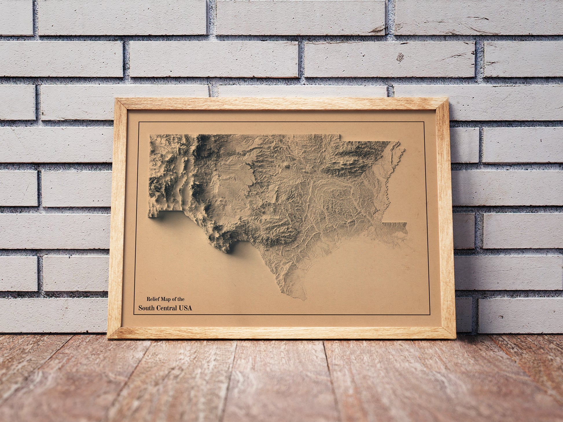 Vintage South Central USA shaded relief map in a wooden frame. Realistic terrain art print for home decor, displayed against a brick wall
