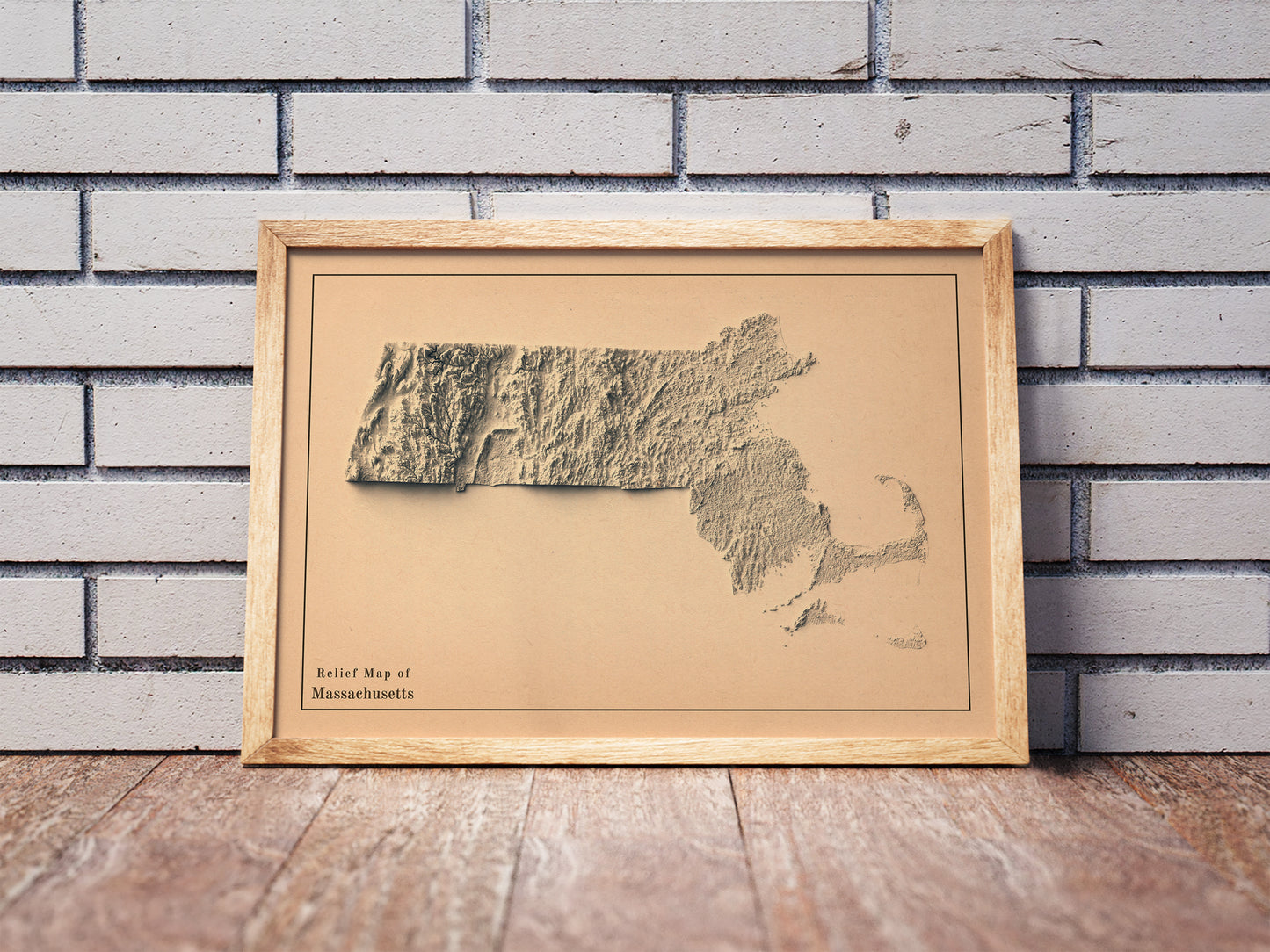 Vintage Massachusetts shaded relief map in a wooden frame. Realistic terrain art print for home decor, displayed against a brick wall