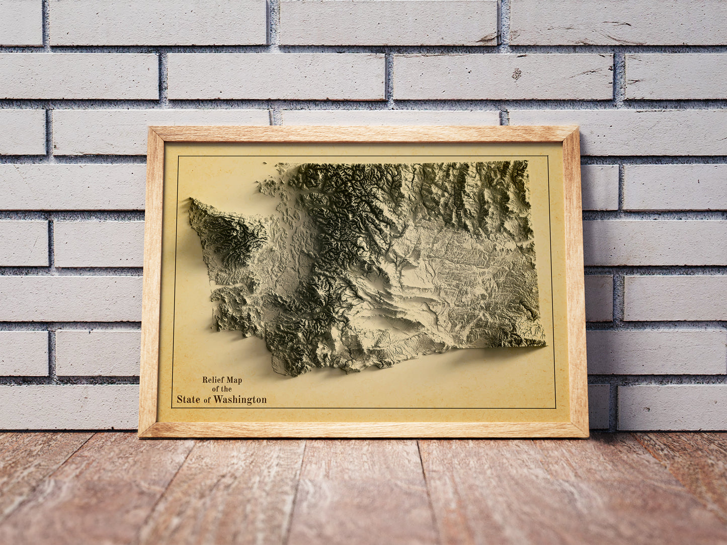Vintage Washington shaded relief map in a wooden frame. Realistic terrain art print for home decor, displayed against a brick wall