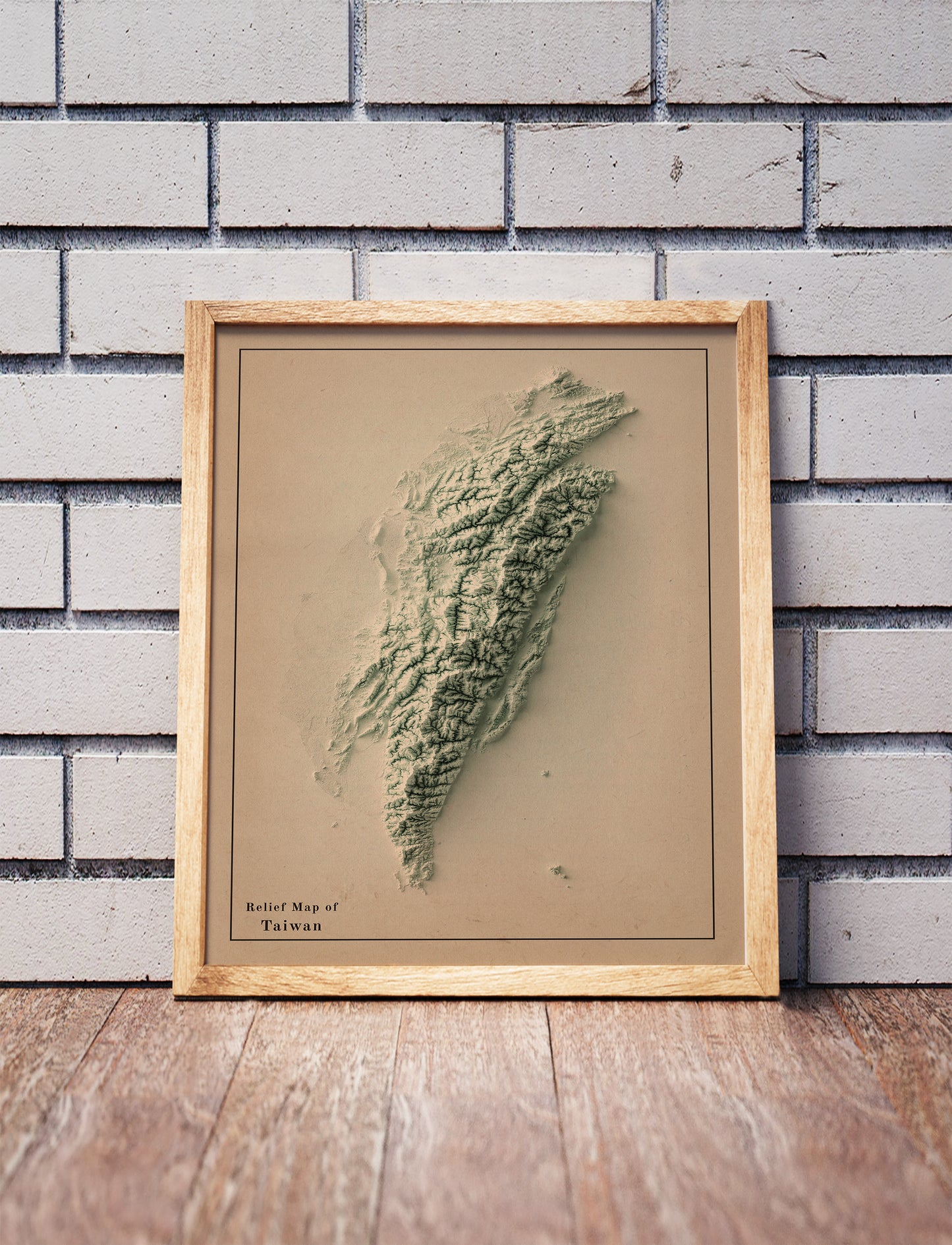 Vintage Taiwan shaded relief map in a wooden frame. Realistic terrain art print for home decor, displayed against a brick wall