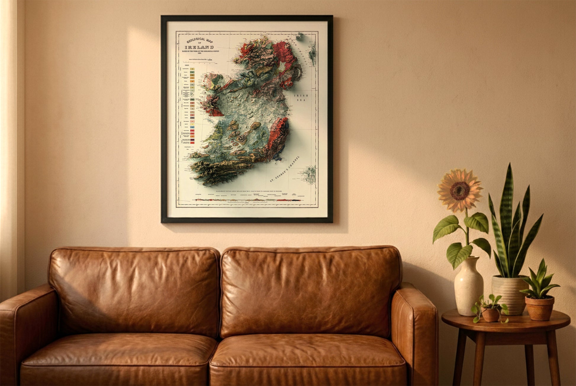 Ireland vintage relief map in a black frame above a brown leather sofa. Boho living room with warm sunlight, sunflower, and indoor plants on a wooden side table