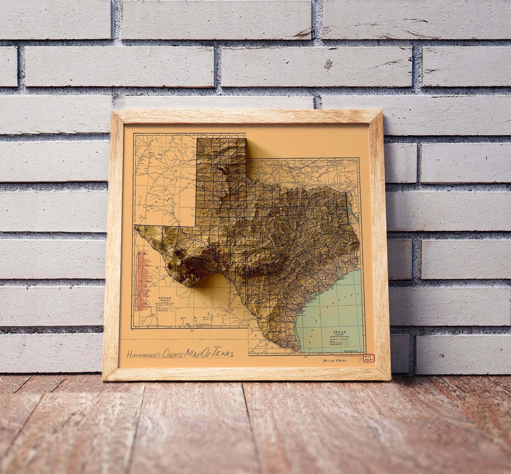 Vintage Texas shaded relief map in a wooden frame. Realistic terrain art print for home decor, displayed against a brick wall