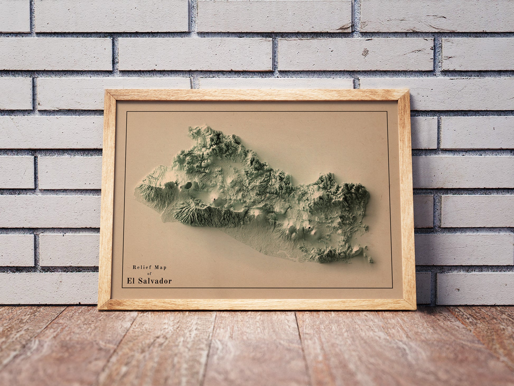 Vintage El Salvador shaded relief map in a wooden frame. Realistic terrain art print for home decor, displayed against a brick wall