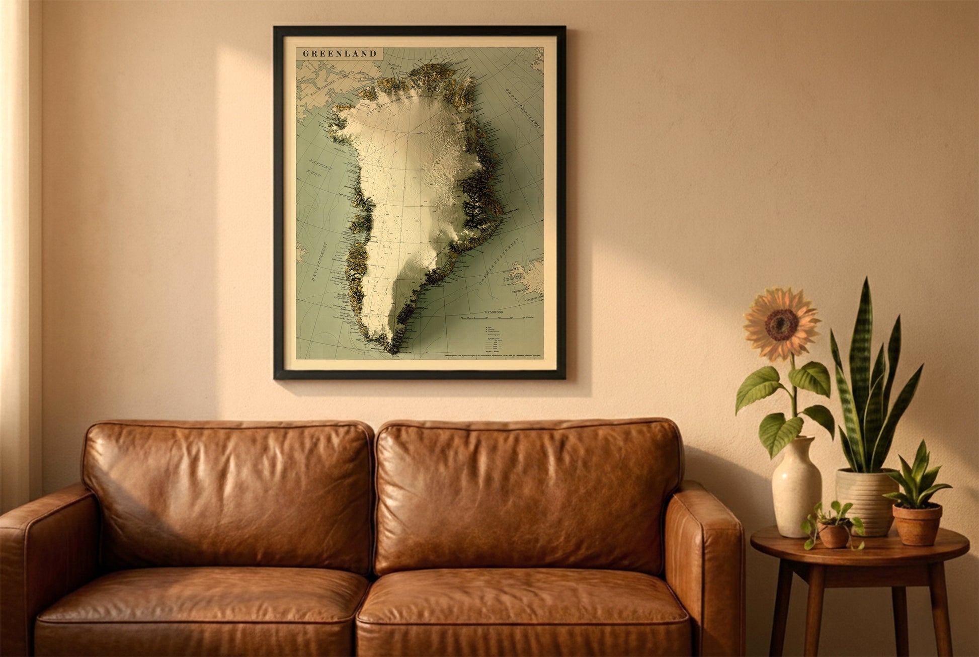 Greenland vintage relief map in a black frame above a brown leather sofa. Boho living room with warm sunlight, sunflower, and indoor plants on a wooden side table