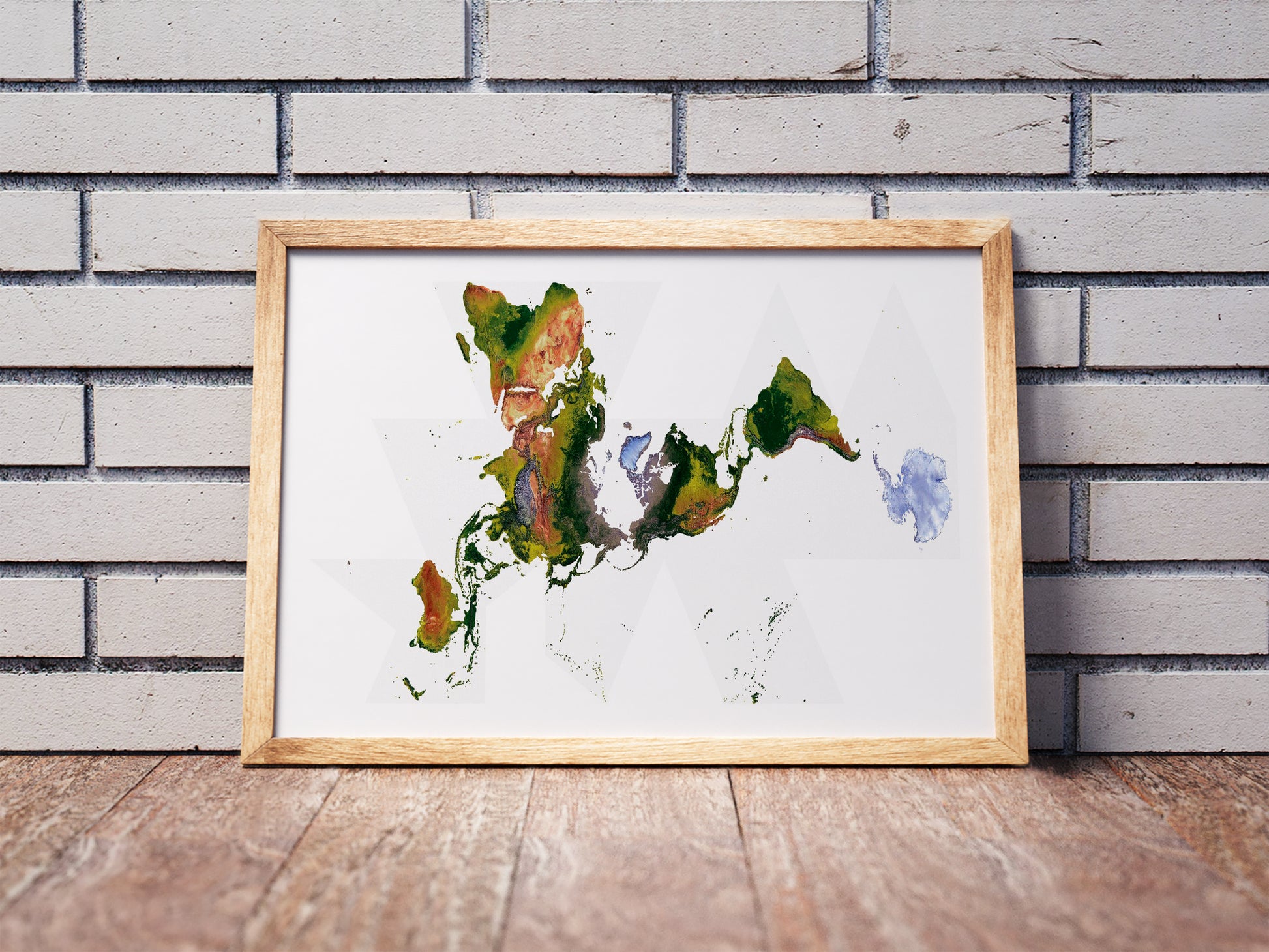 Fuller projection shaded relief world map in a wooden frame. Realistic terrain art print for home decor, displayed against a brick wall