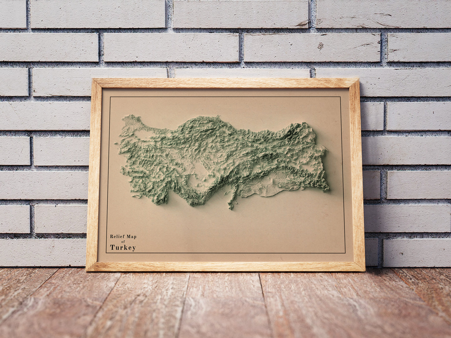Vintage Turkey shaded relief map in a wooden frame. Realistic terrain art print for home decor, displayed against a brick wall
