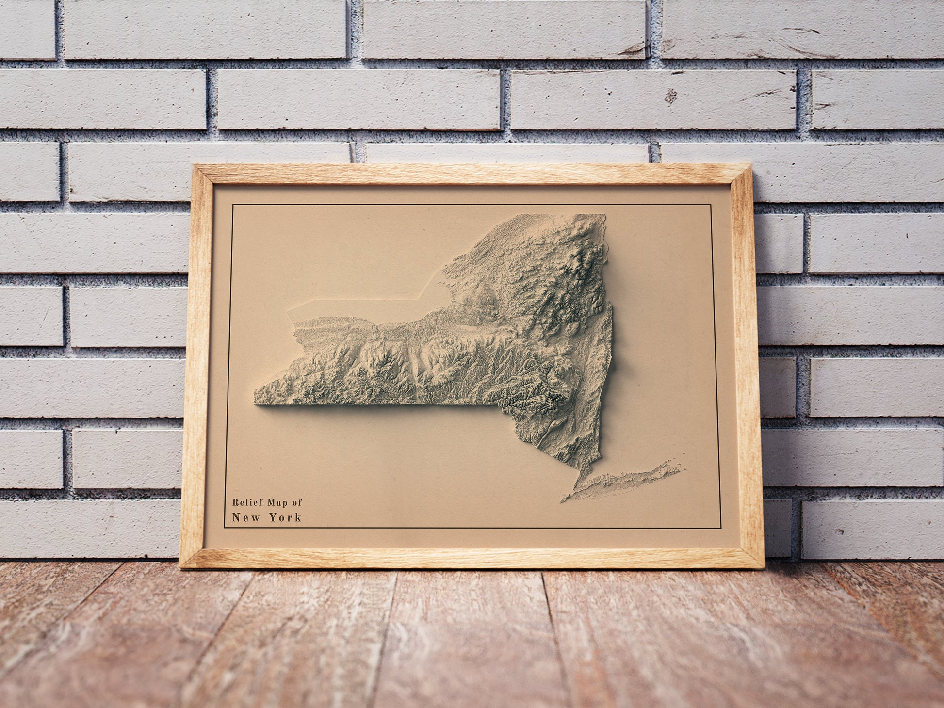 Vintage New York state shaded relief map in a wooden frame. Realistic terrain art print for home decor, displayed against a brick wall