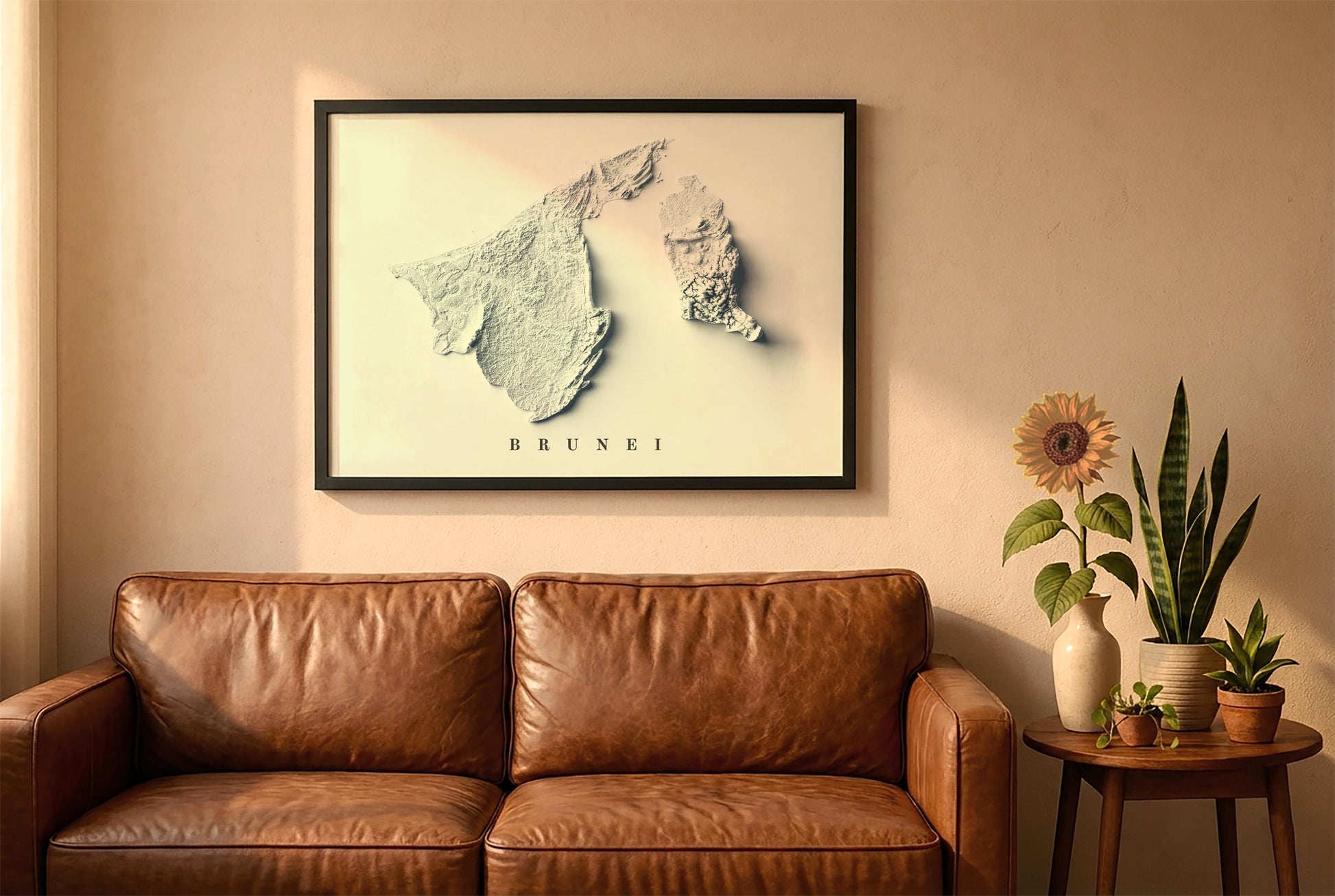 Brunei relief map in a black frame above a brown leather sofa. Boho living room with warm sunlight, sunflower, and indoor plants on a wooden side table