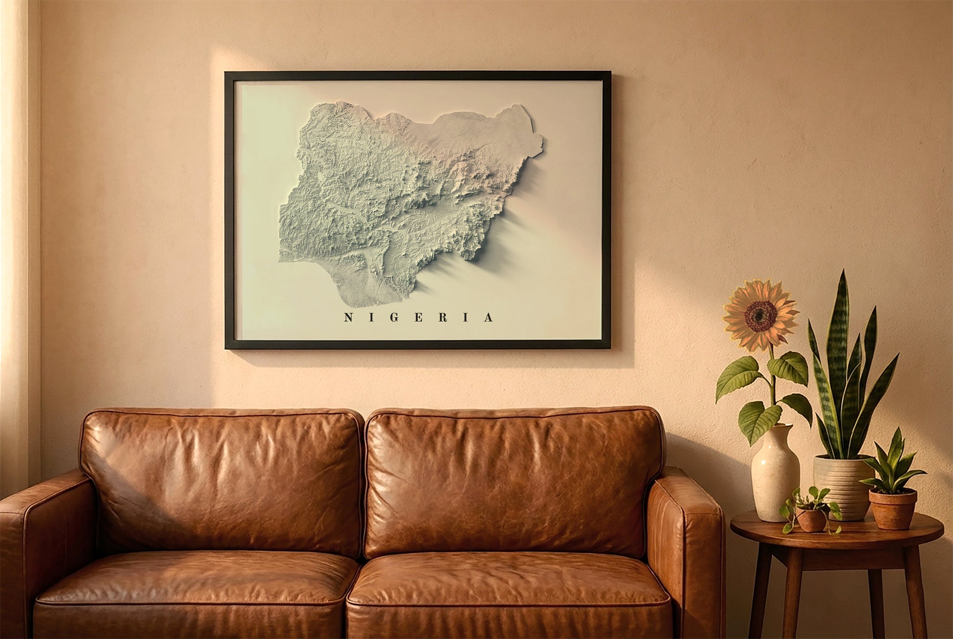 Nigeria relief map in a black frame above a brown leather sofa. Boho living room with warm sunlight, sunflower, and indoor plants on a wooden side table