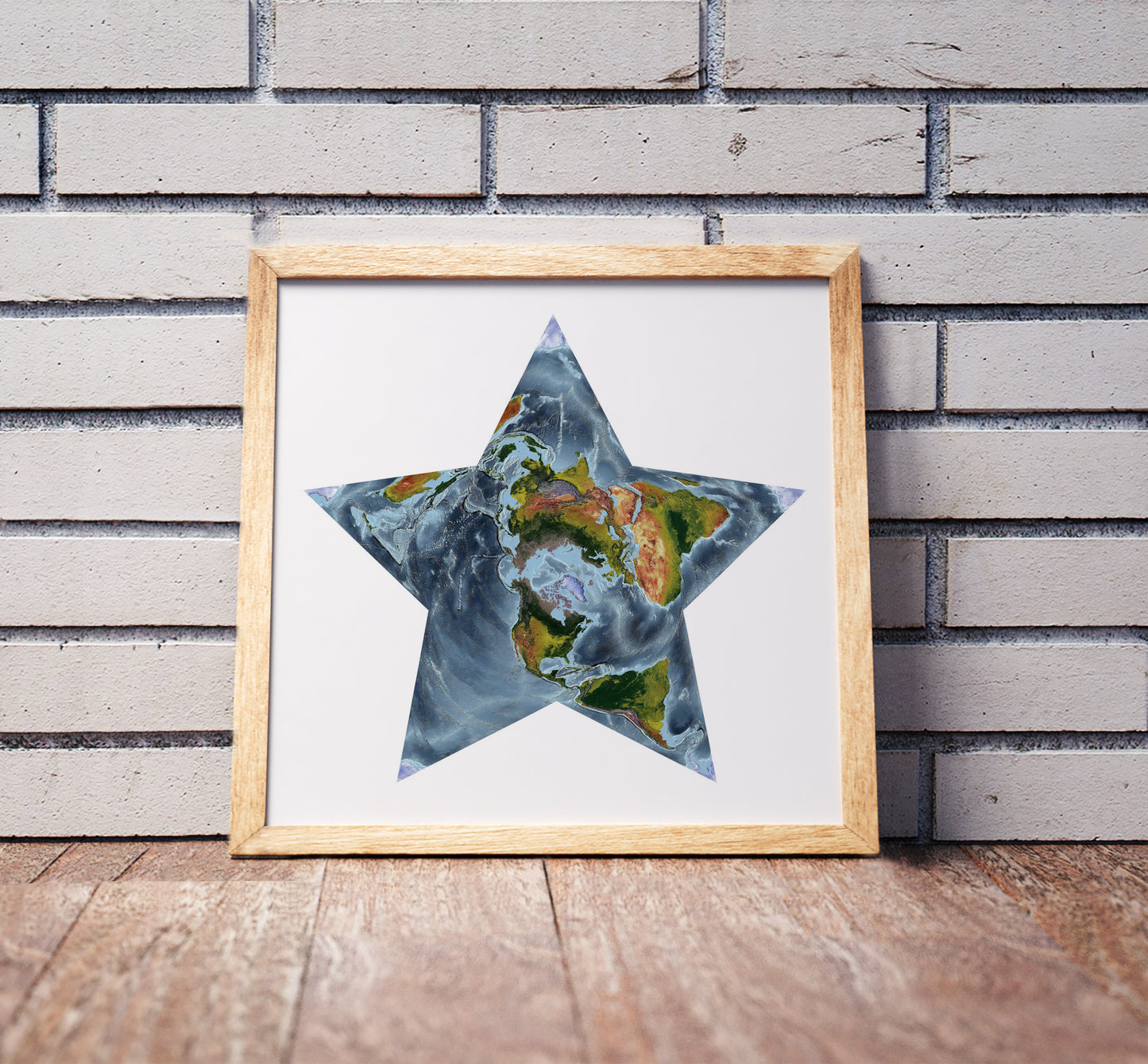 Berghaus projection shaded relief world map in a wooden frame. Realistic terrain art print for home decor, displayed against a brick wall