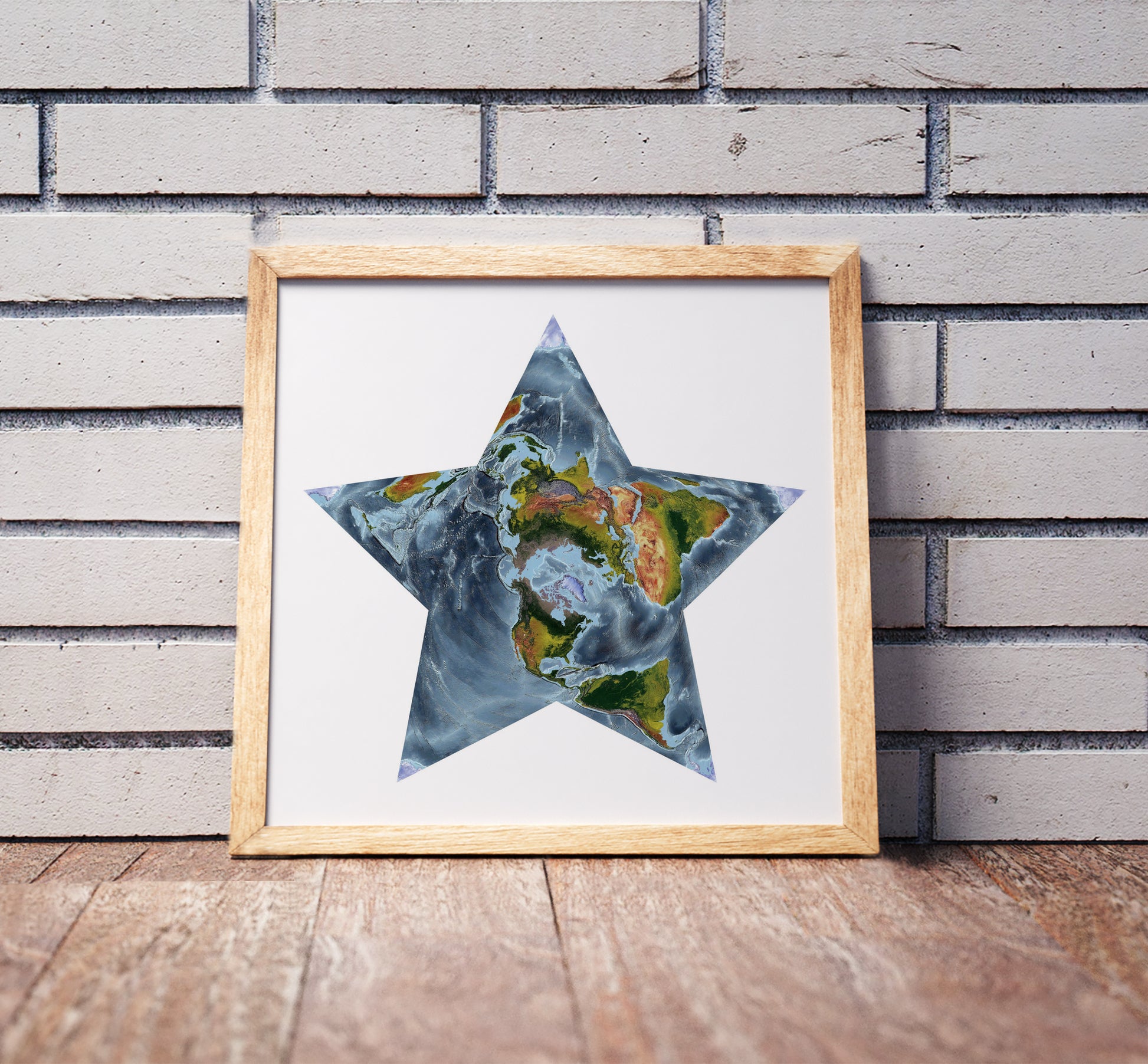 Berghaus projection shaded relief world map in a wooden frame. Realistic terrain art print for home decor, displayed against a brick wall