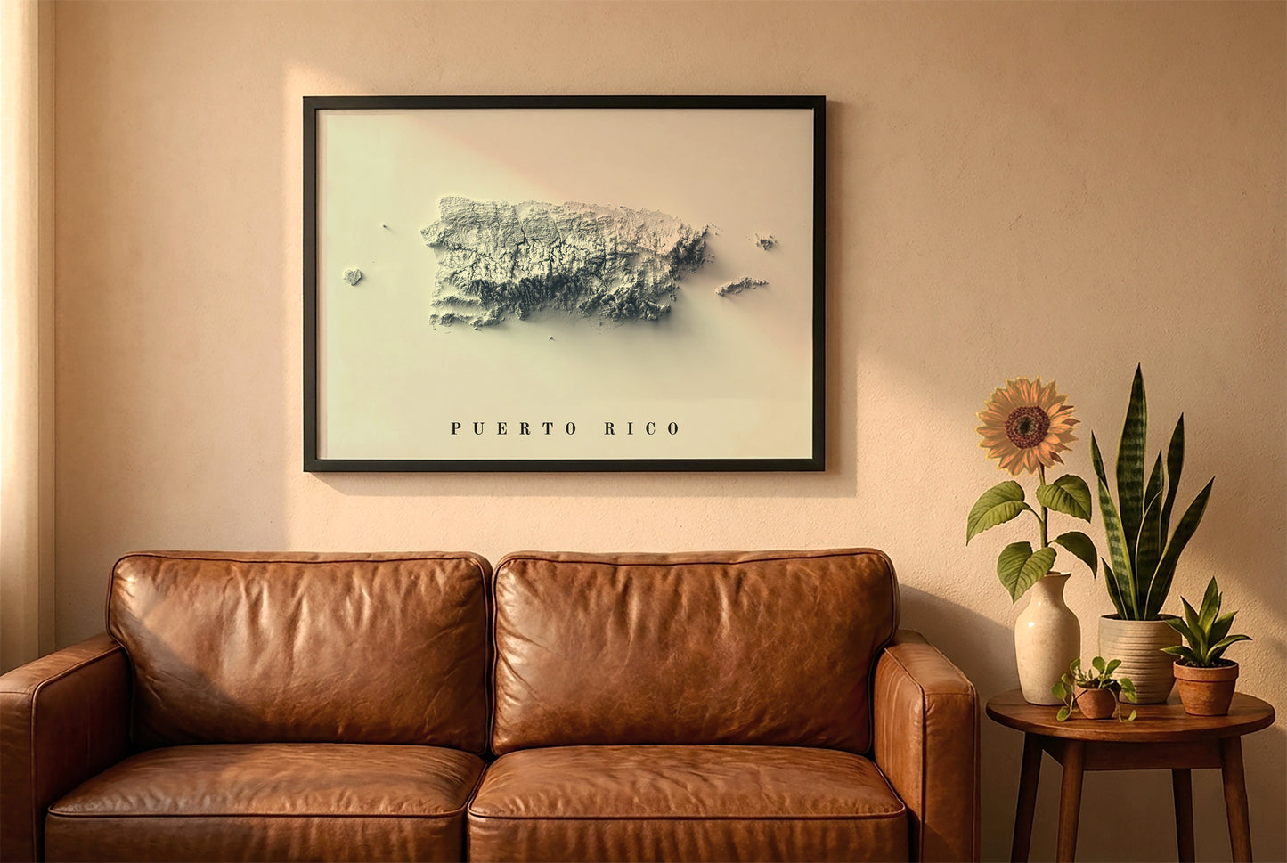 Puerto Rico relief map in a black frame above a brown leather sofa. Boho living room with warm sunlight, sunflower, and indoor plants on a wooden side table