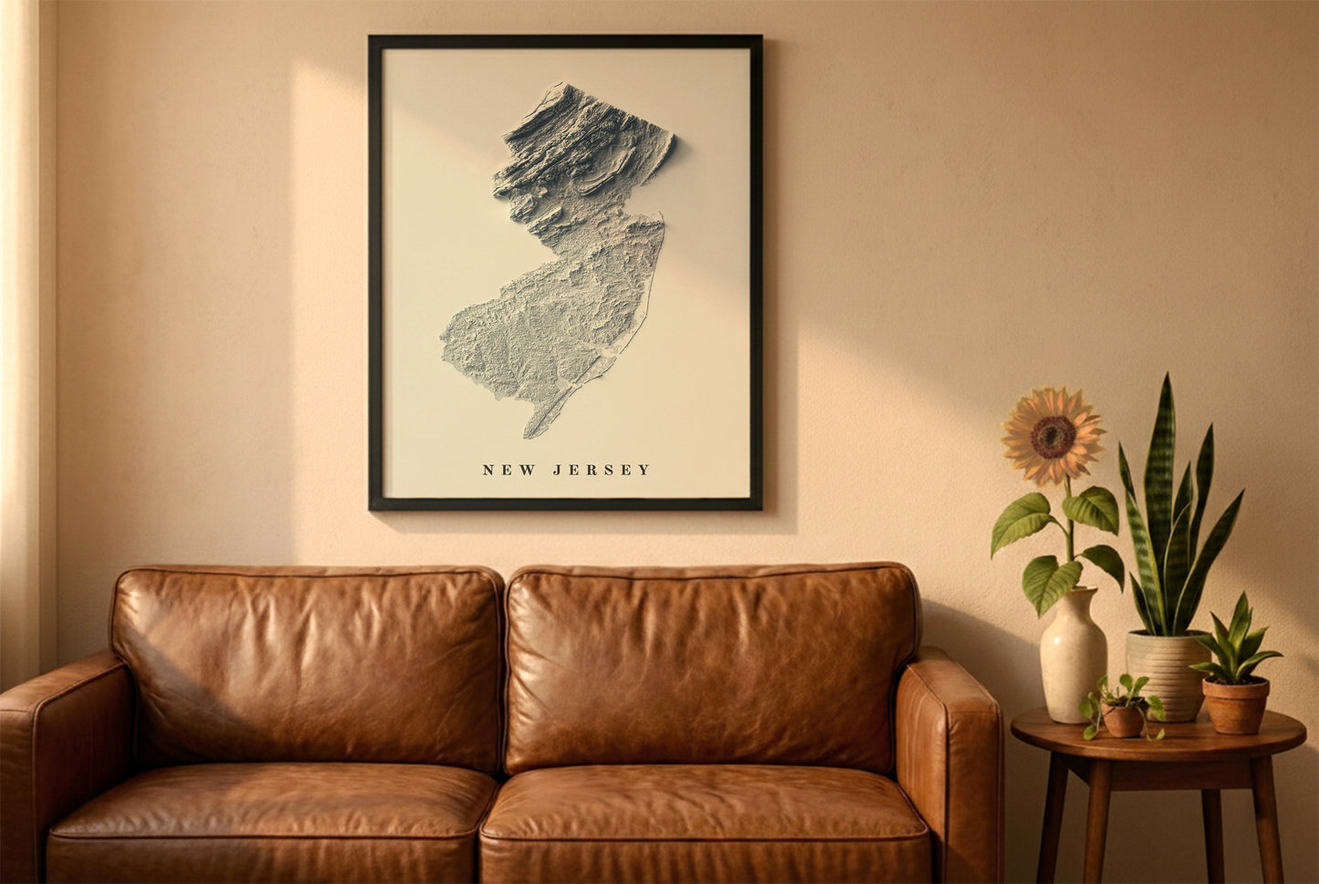 New Jersey relief map in a black frame above a brown leather sofa. Boho living room with warm sunlight, sunflower, and indoor plants on a wooden side table