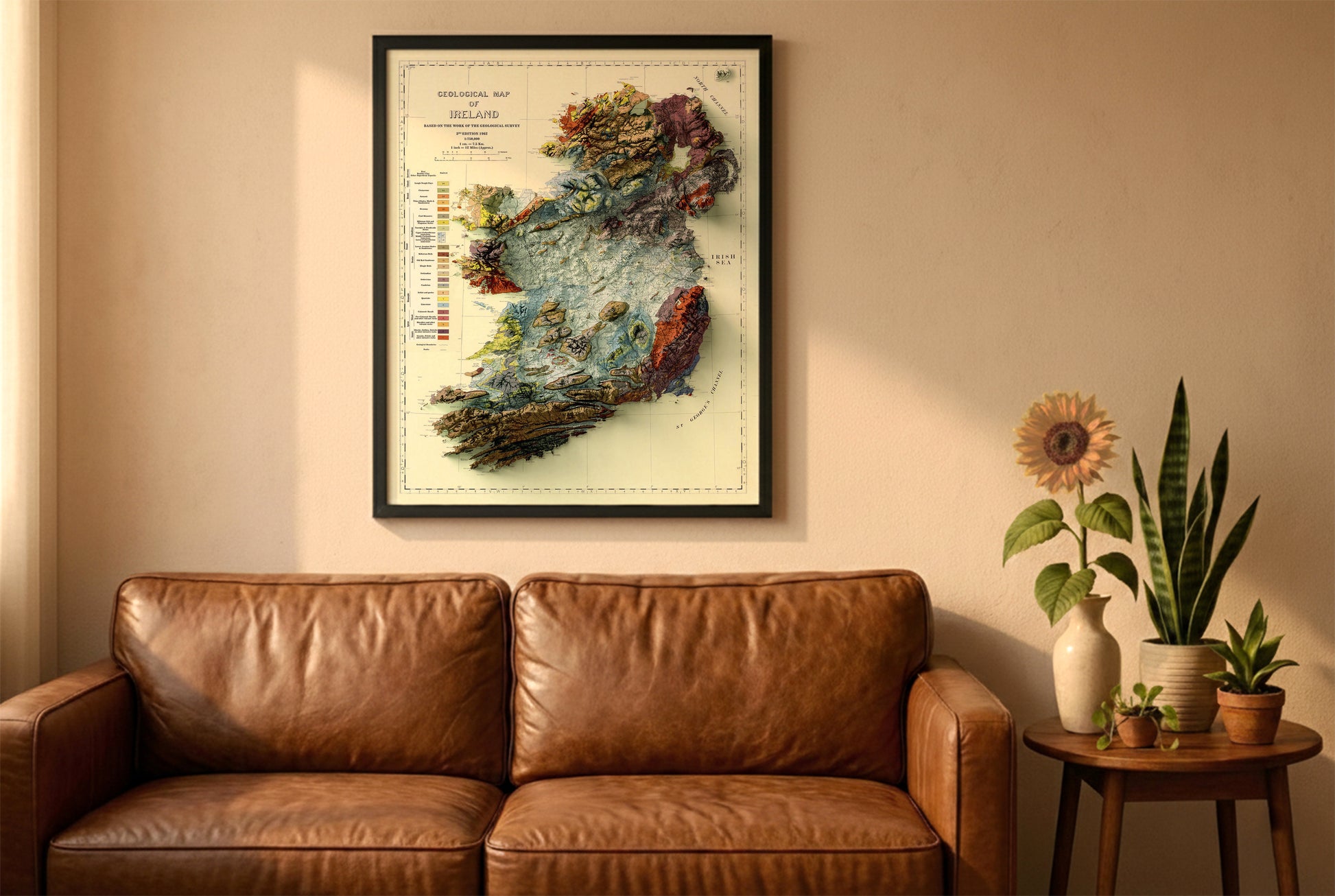 Ireland vintage relief map in a black frame above a brown leather sofa. Boho living room with warm sunlight, sunflower, and indoor plants on a wooden side table