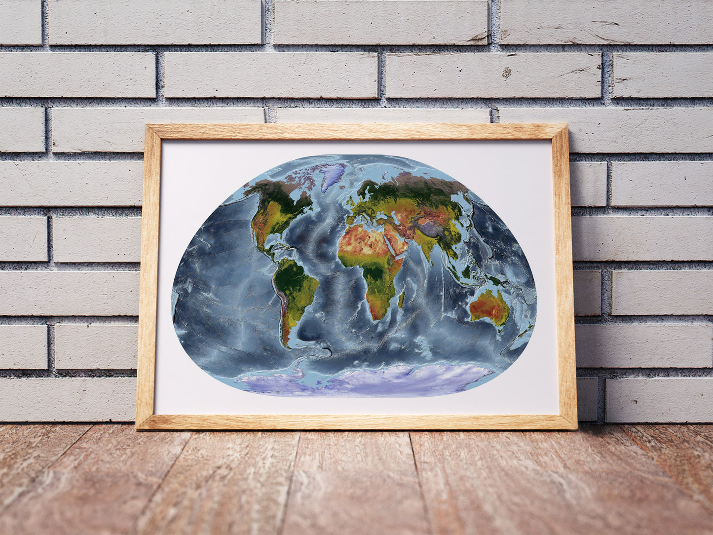 Loximuthal projection shaded relief world map in a wooden frame. Realistic terrain art print for home decor, displayed against a brick wall