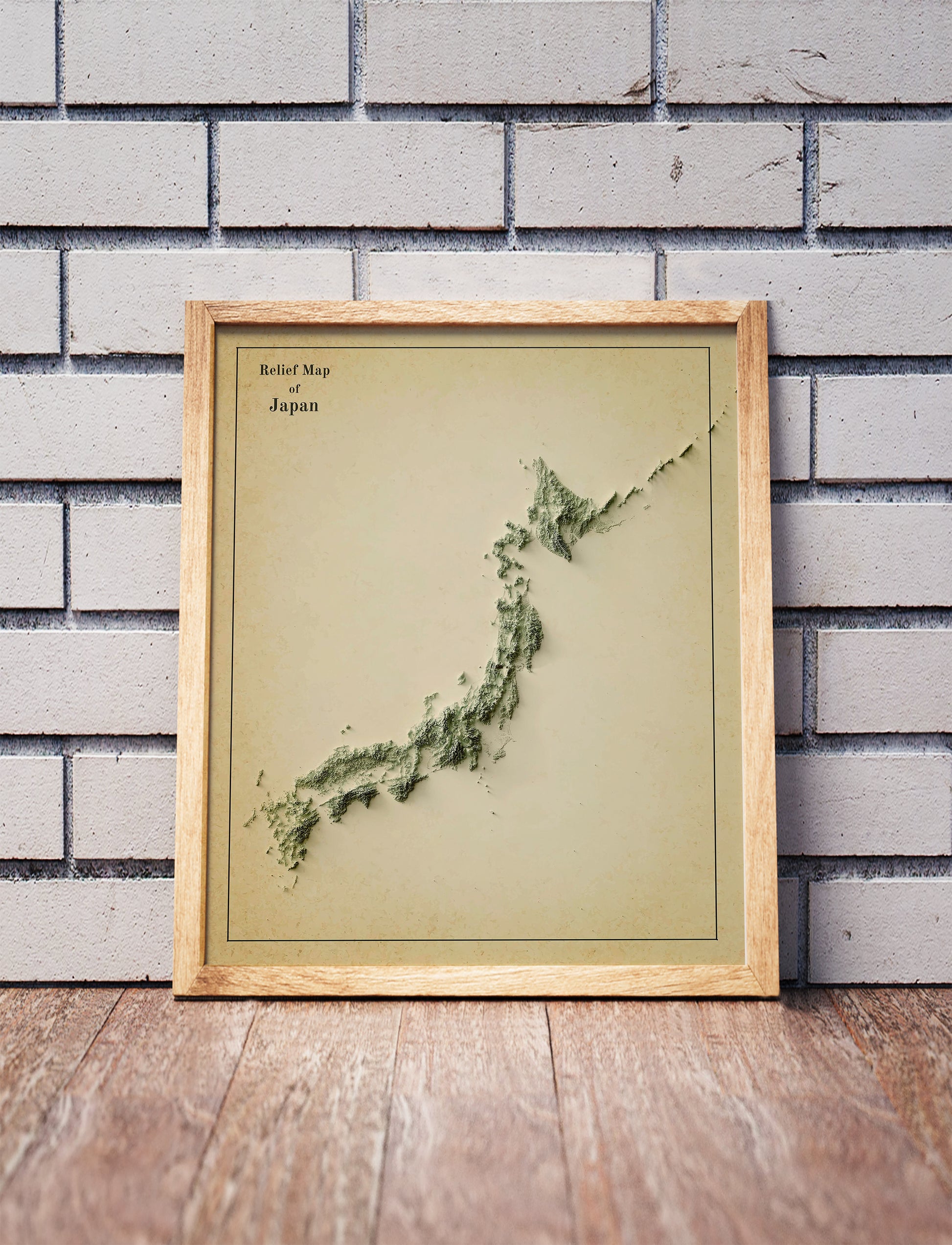 Vintage Japan shaded relief map in a wooden frame. Realistic terrain art print for home decor, displayed against a brick wall