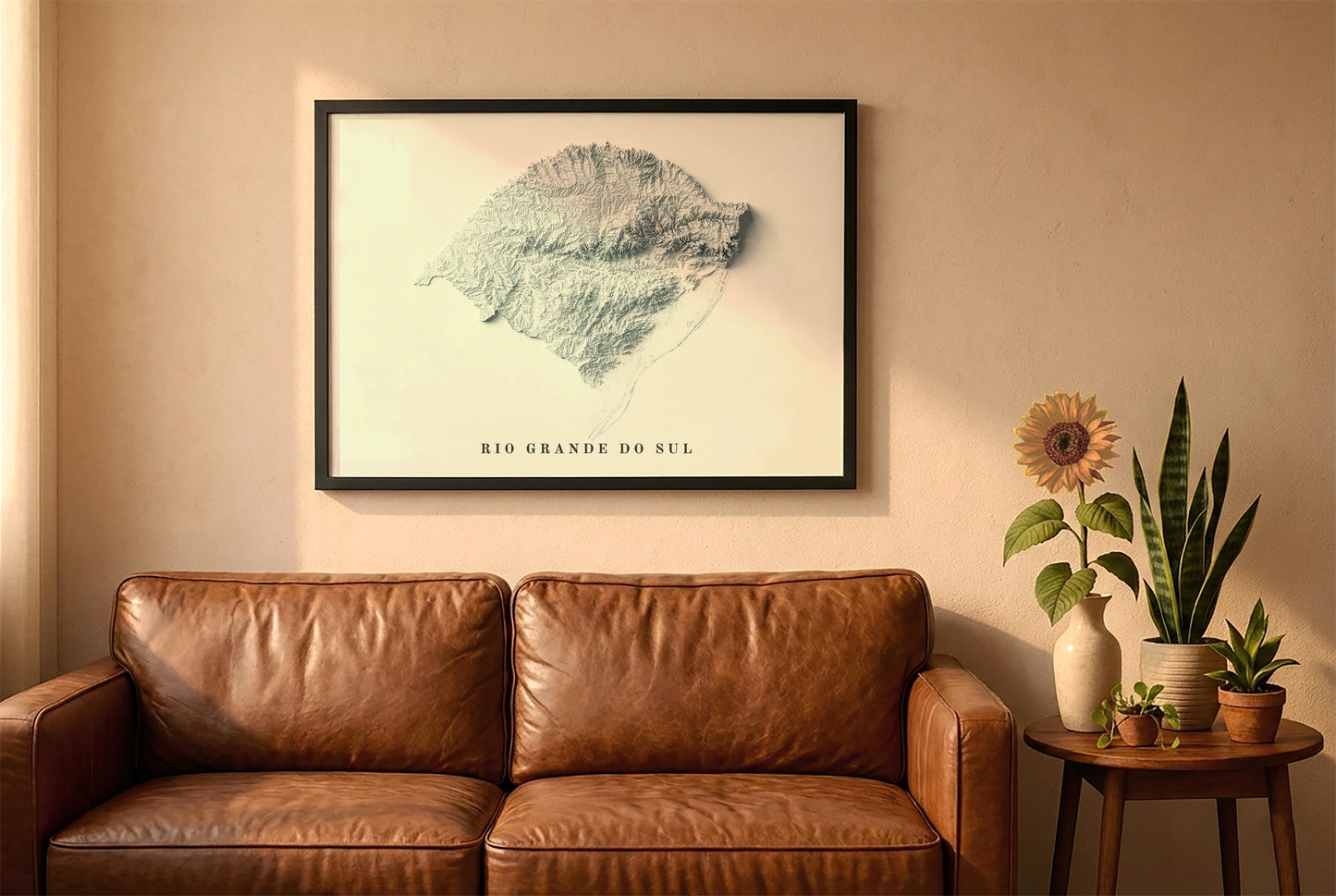 Rio Grande do Sul, Brazil, relief map in a black frame above a brown leather sofa. Boho living room with warm sunlight, sunflower, and indoor plants on a wooden side table