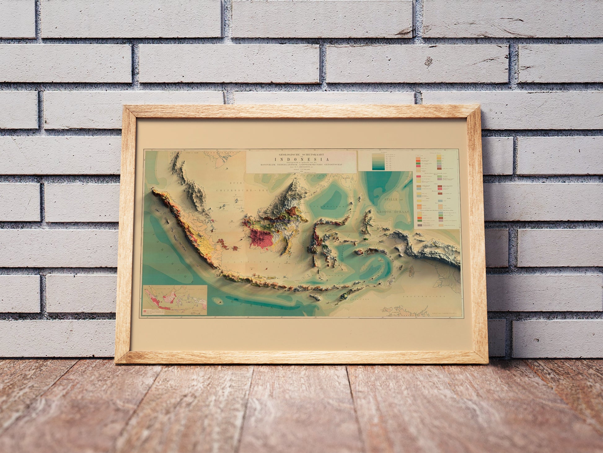 Vintage Indonesia shaded relief map in a wooden frame. Realistic terrain art print for home decor, displayed against a brick wall