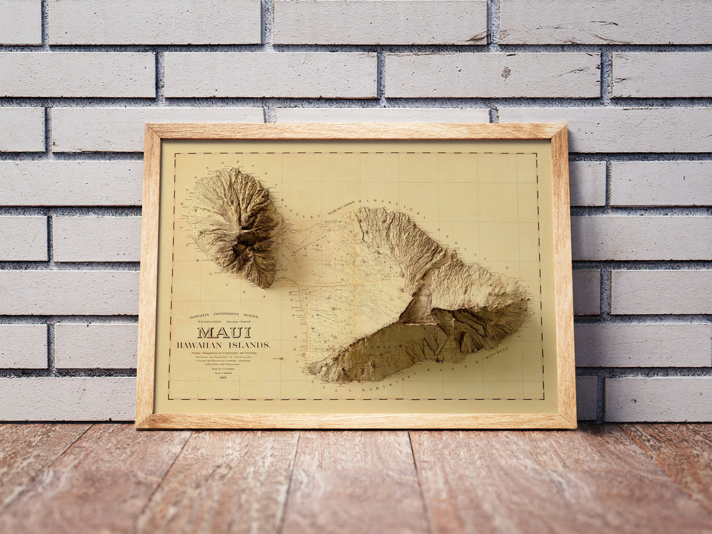 Vintage Maui, Hawaii, shaded relief map in a wooden frame. Realistic terrain art print for home decor, displayed against a brick wall