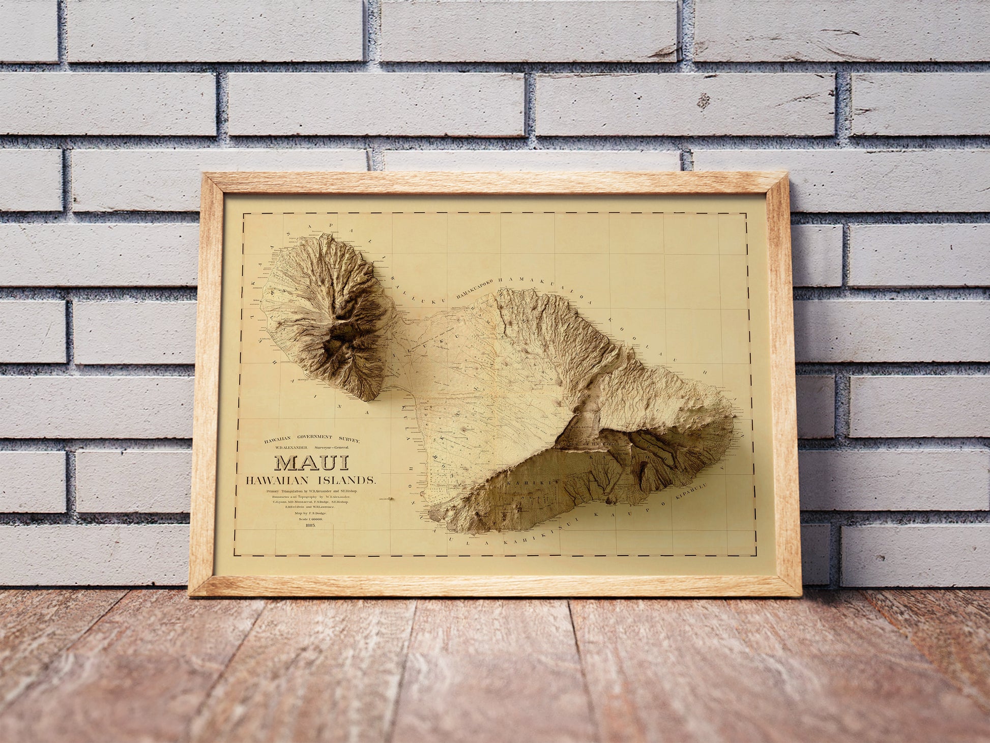 Vintage Maui, Hawaii, shaded relief map in a wooden frame. Realistic terrain art print for home decor, displayed against a brick wall