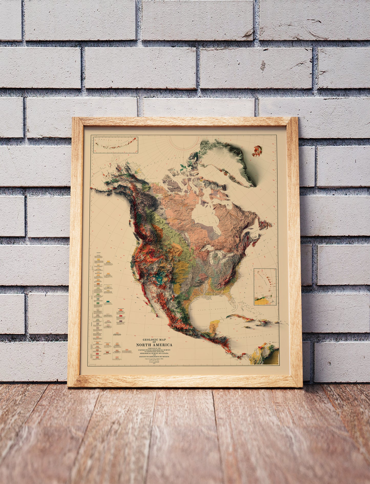 Vintage North and Central Americas shaded relief map in a wooden frame. Realistic terrain art print for home decor, displayed against a brick wall