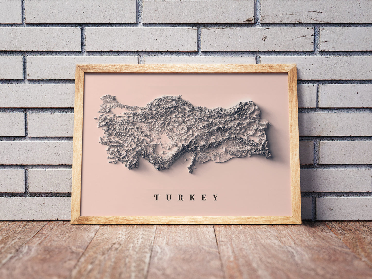 Turkey shaded relief map in a wooden frame. Realistic terrain art print for home decor, displayed against a brick wall