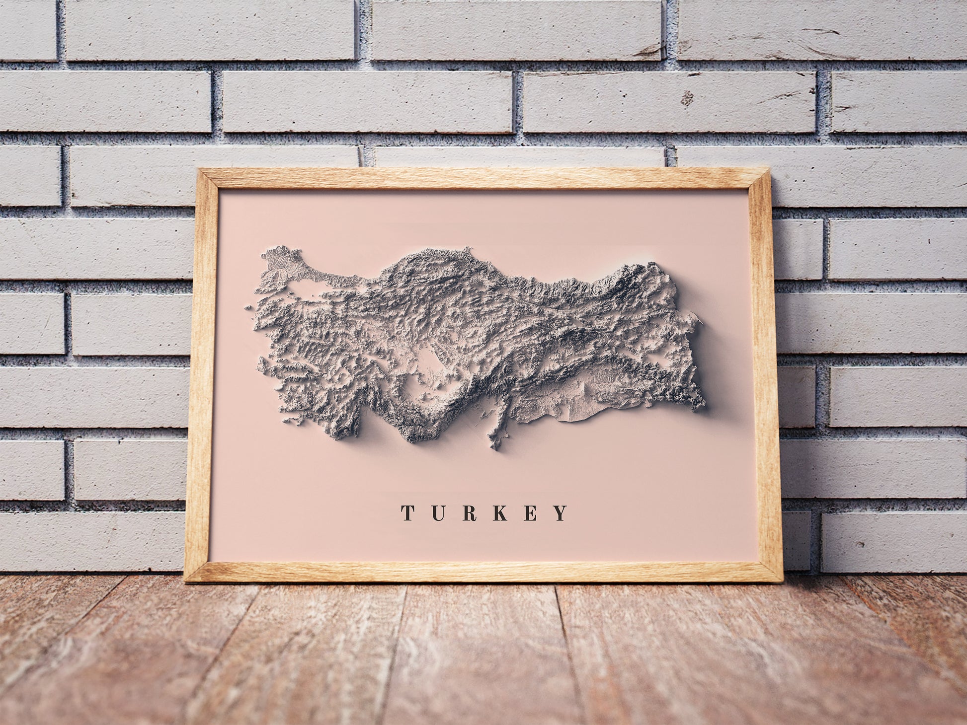 Turkey shaded relief map in a wooden frame. Realistic terrain art print for home decor, displayed against a brick wall