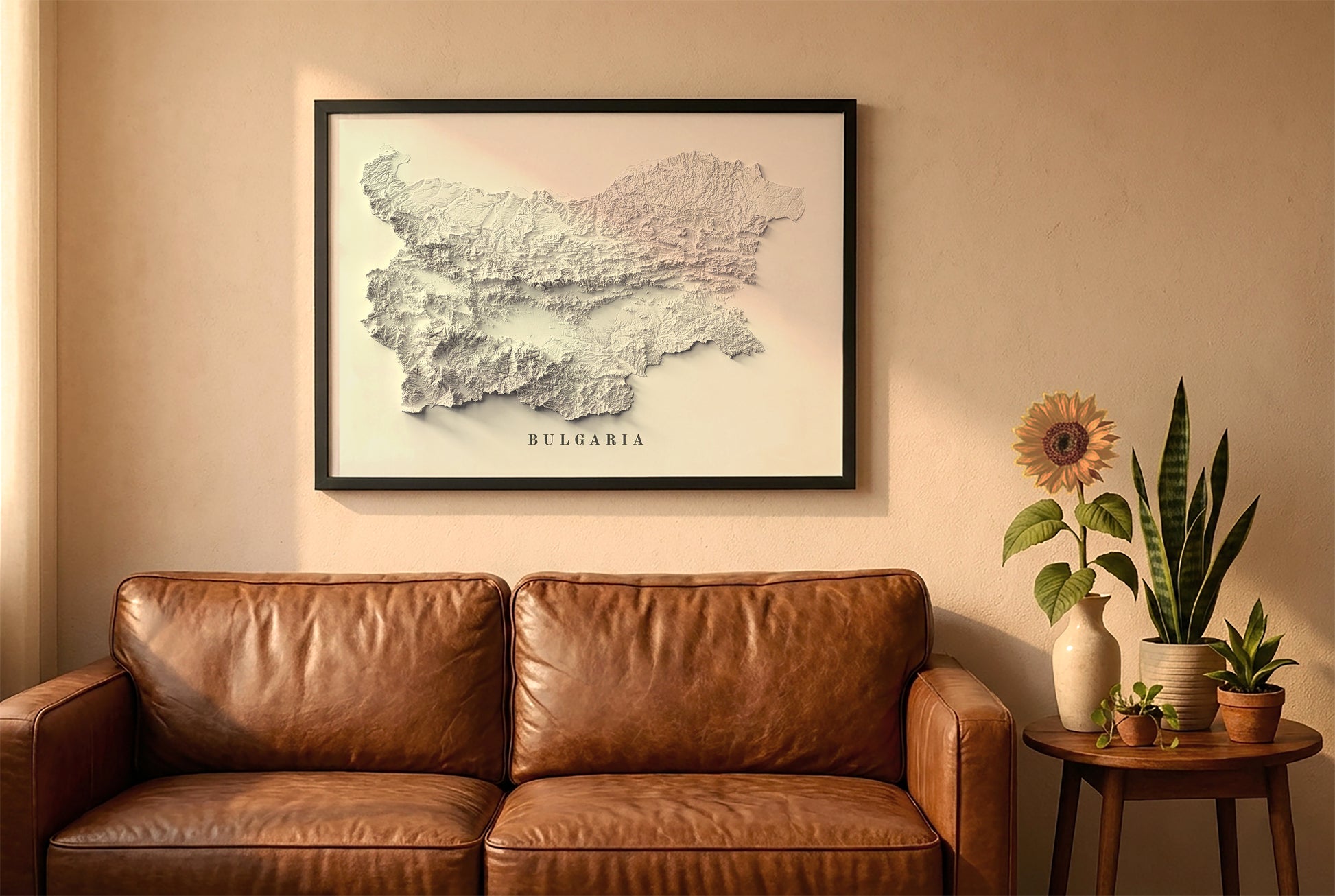 Bulgaria relief map in a black frame above a brown leather sofa. Boho living room with warm sunlight, sunflower, and indoor plants on a wooden side table