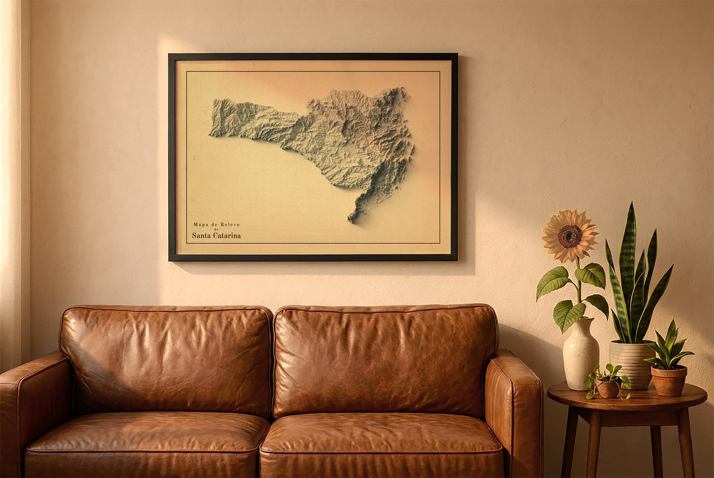 Santa Catarina, Brazil, vintage relief map in a black frame above a brown leather sofa. Boho living room with warm sunlight, sunflower, and indoor plants on a wooden side table