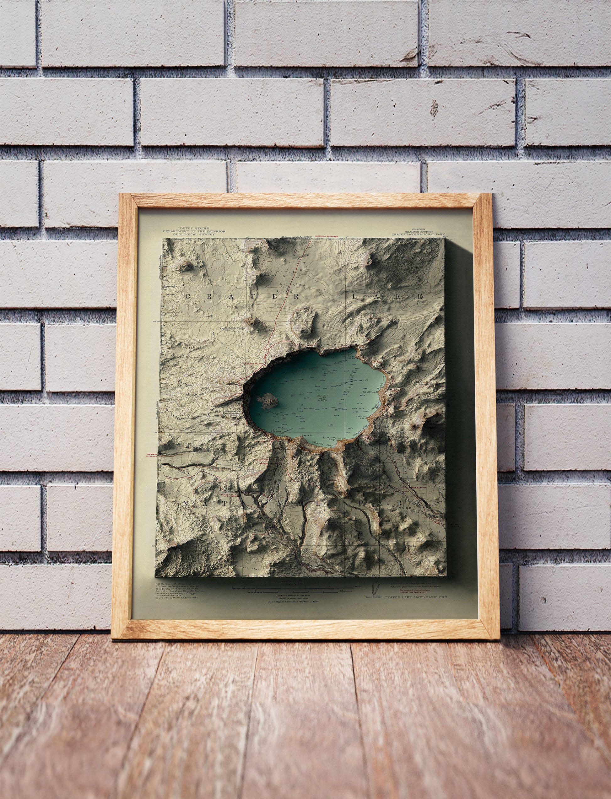 Vintage Crater Lake, Oregon, shaded relief map in a wooden frame. Realistic terrain art print for home decor, displayed against a brick wall
