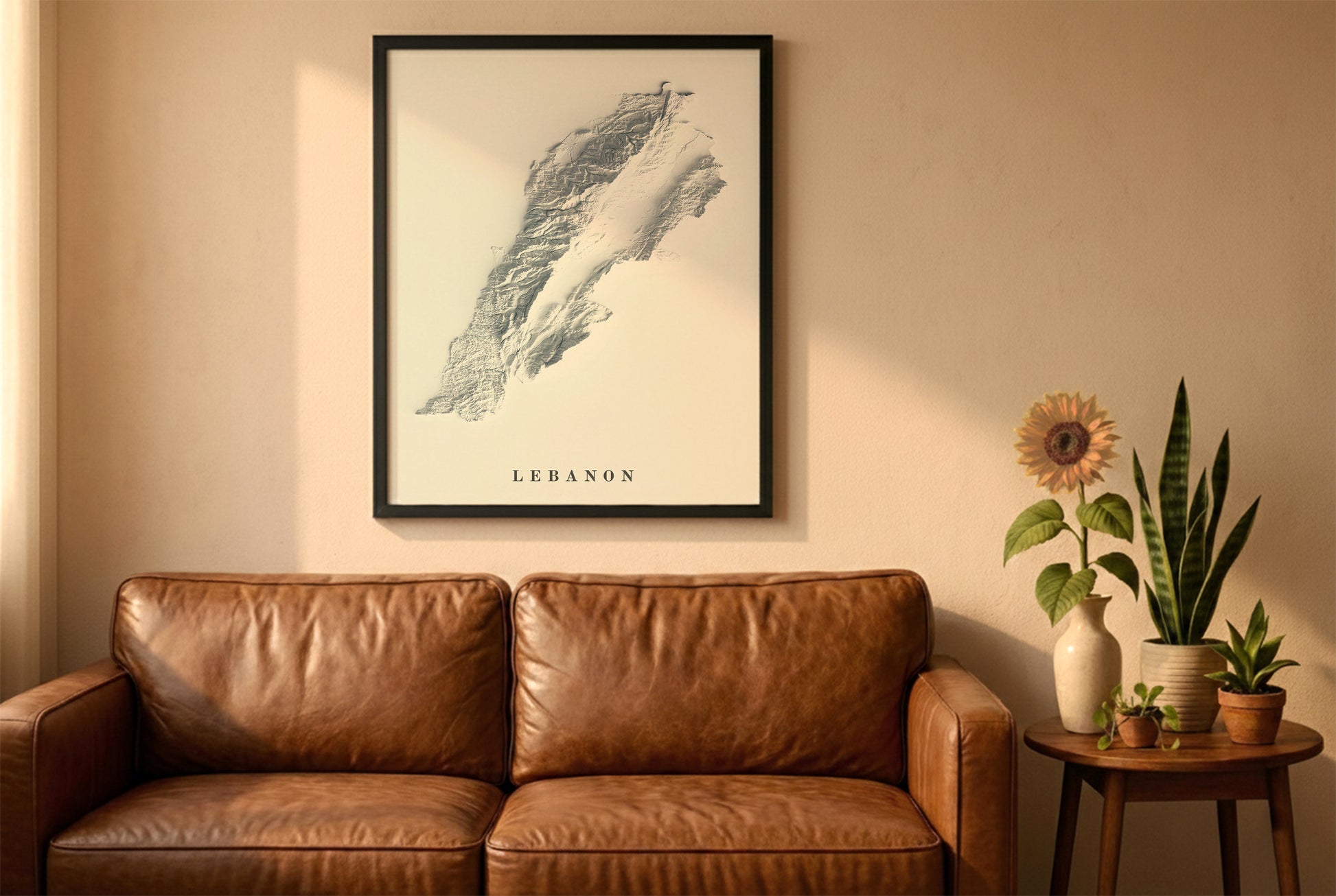 Lebanon relief map in a black frame above a brown leather sofa. Boho living room with warm sunlight, sunflower, and indoor plants on a wooden side table