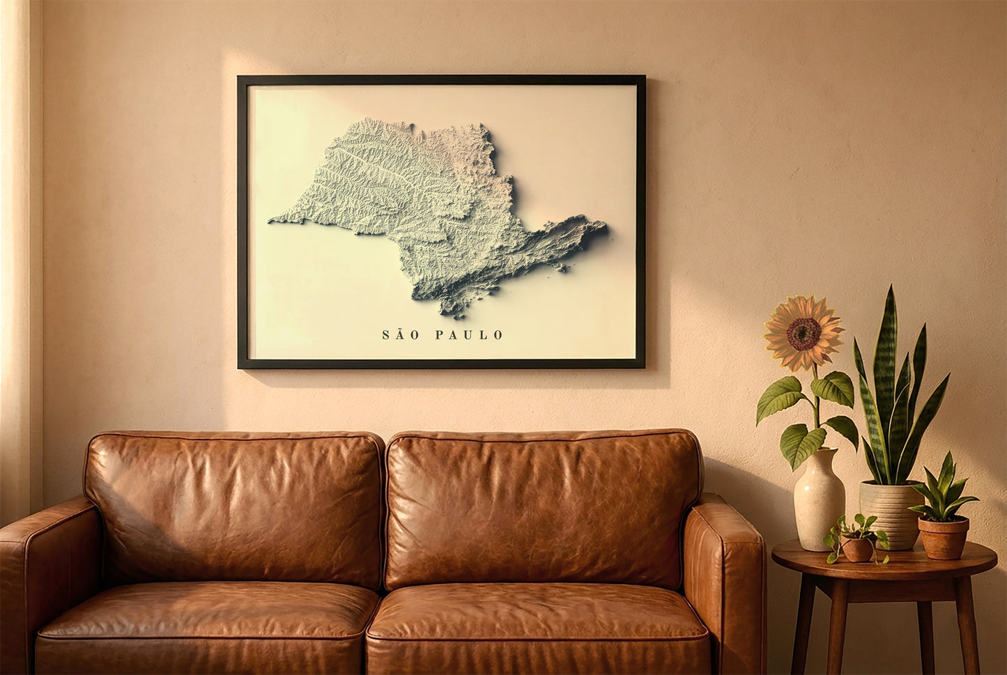 Sao Paulo, Brazil, relief map in a black frame above a brown leather sofa. Boho living room with warm sunlight, sunflower, and indoor plants on a wooden side table