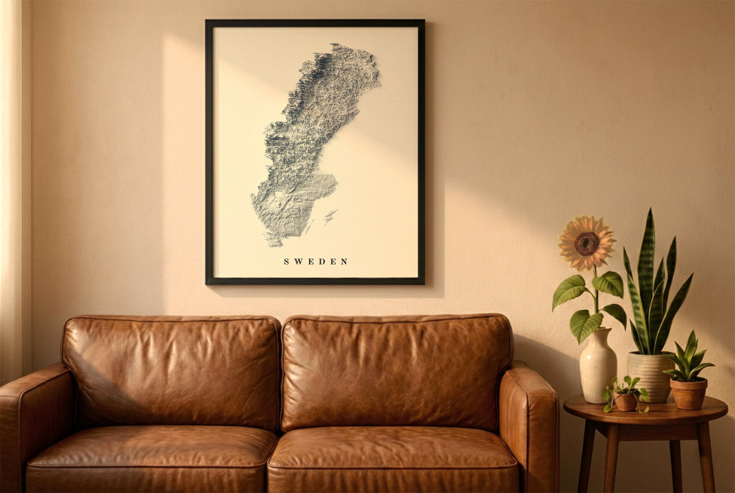 Sweden relief map in a black frame above a brown leather sofa. Boho living room with warm sunlight, sunflower, and indoor plants on a wooden side table