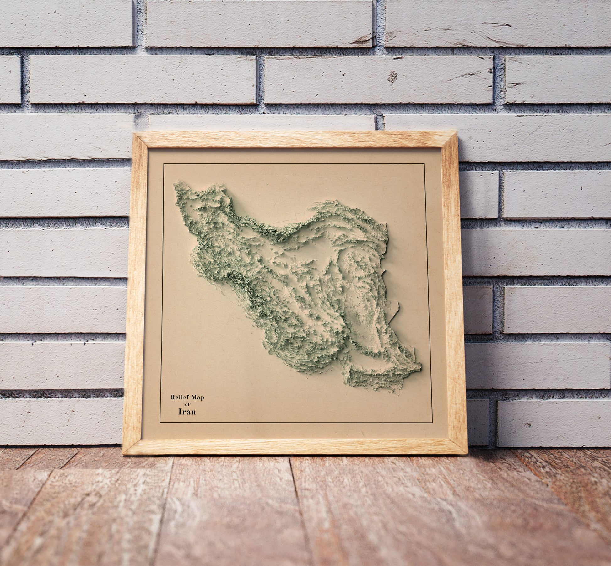 Vintage Iran shaded relief map in a wooden frame. Realistic terrain art print for home decor, displayed against a brick wall